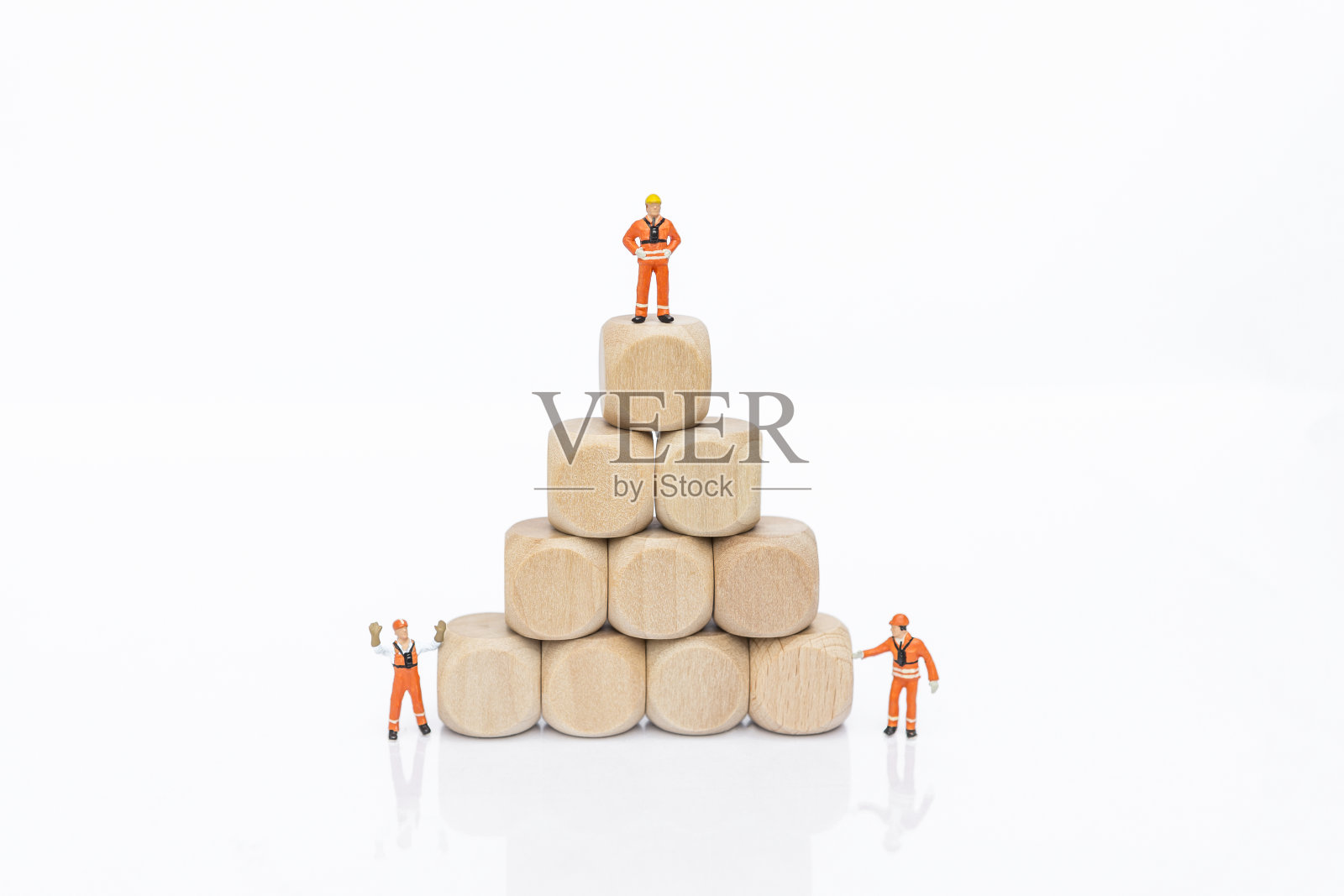 在白色背景上，有一堆小木块的微型工人照片摄影图片