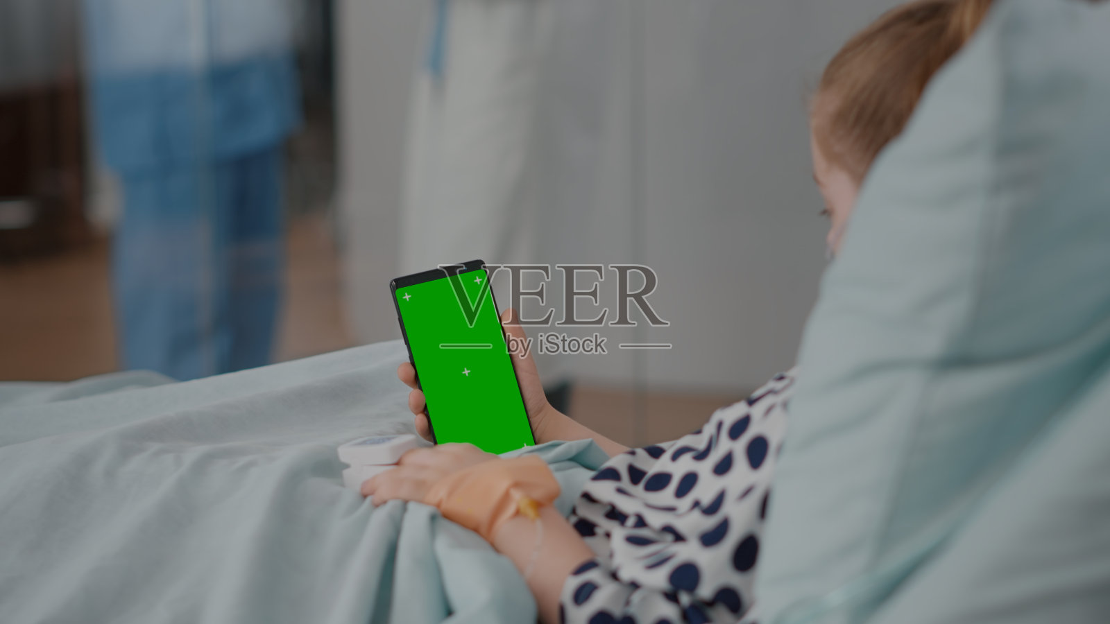 小孩拿着模拟绿屏色度键手机，孤立显示照片摄影图片