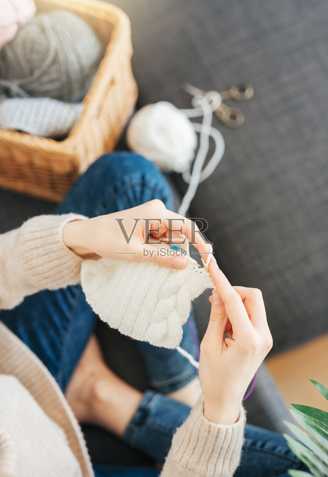 年轻女子在室内编织暖和的围巾照片摄影图片