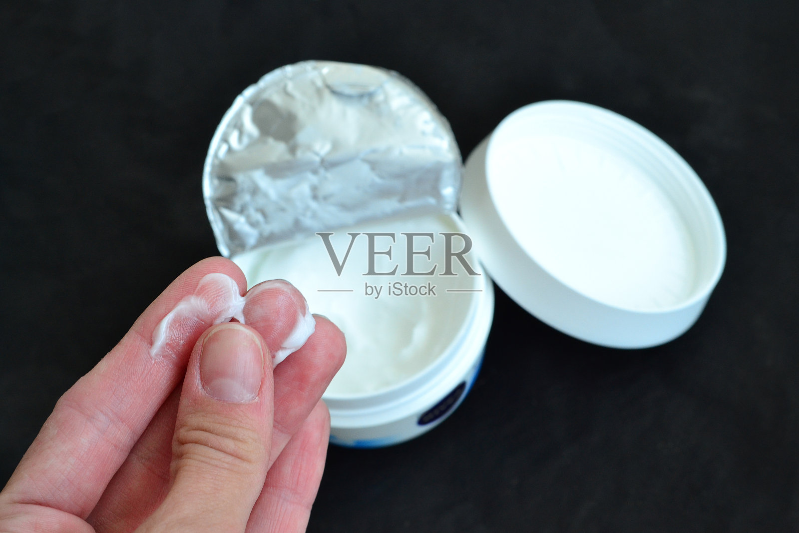 女孩用面霜润滑双手照片摄影图片