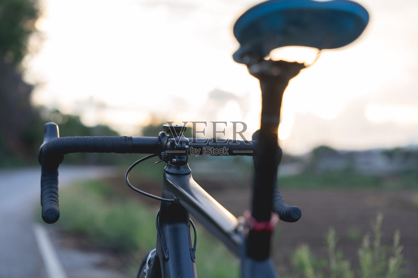 公路上的自行车停在美丽的路上夕阳，温暖的灯光与复制空间。照片摄影图片