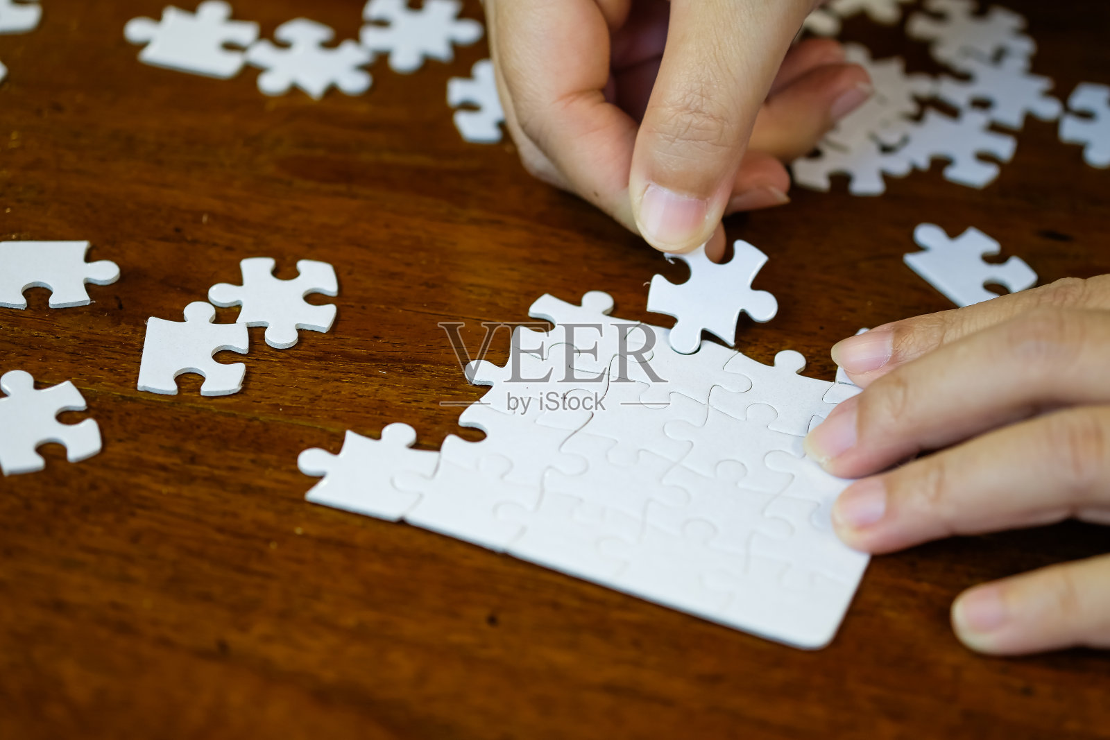 手握拼图片纹理图案木桌背景。照片摄影图片