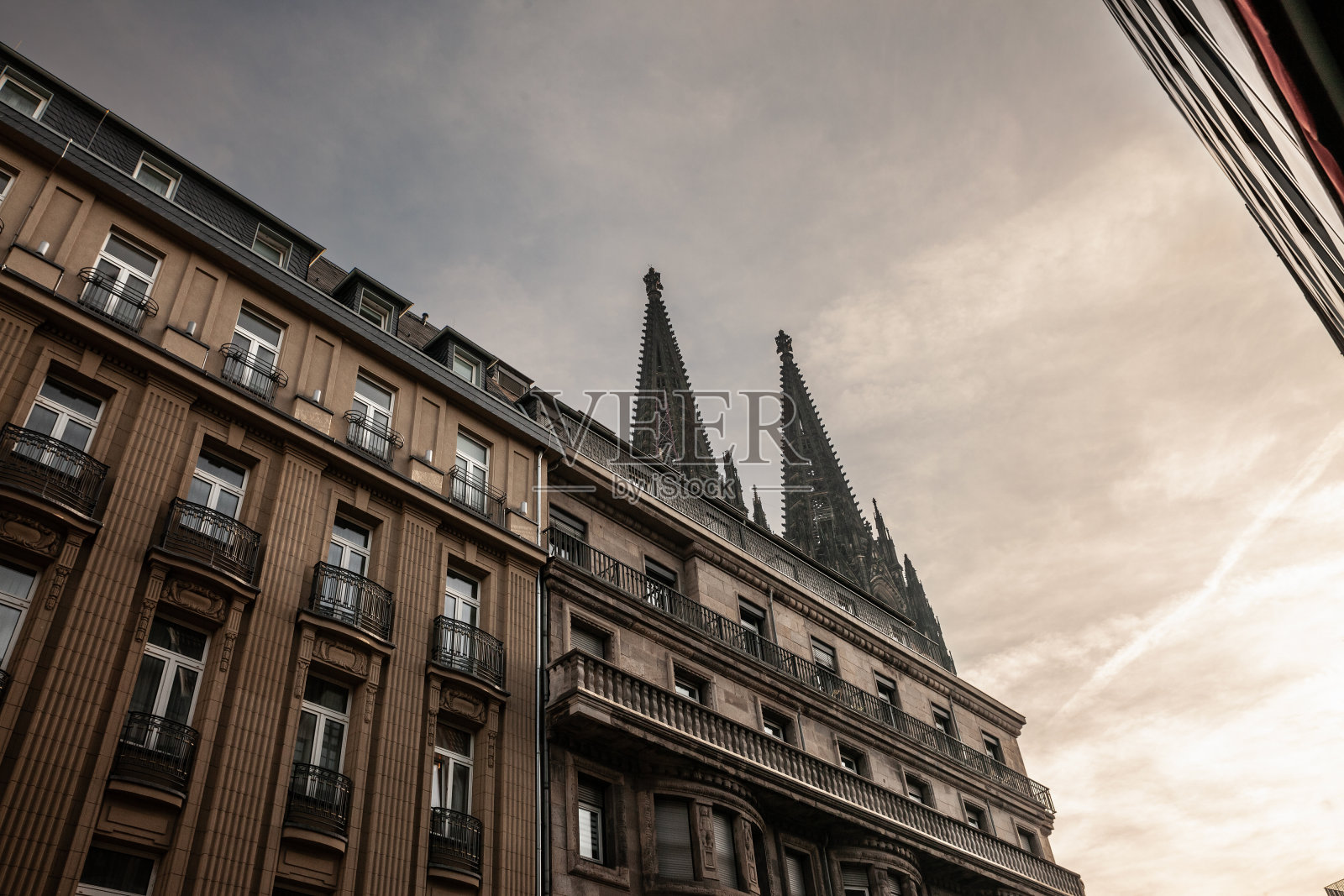 科隆大教堂前有一座住宅公寓楼，前面是蓝天。科隆大教堂(Kolner Dom)是科隆的主要地标，也是德国的一座天主教堂。照片摄影图片