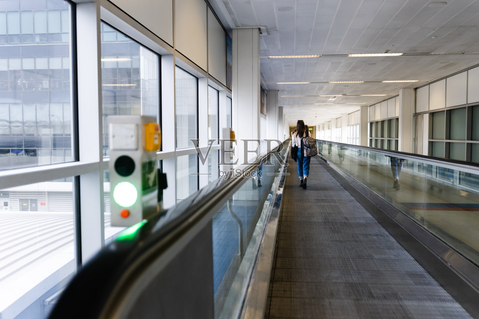 走过机场窗口的女人照片摄影图片