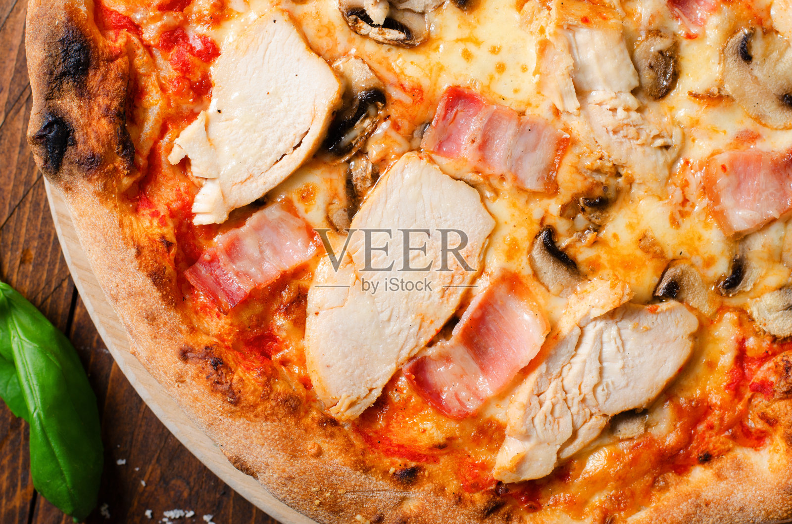 鸡肉，培根，蘑菇披萨木制背景，石头烤披萨照片摄影图片