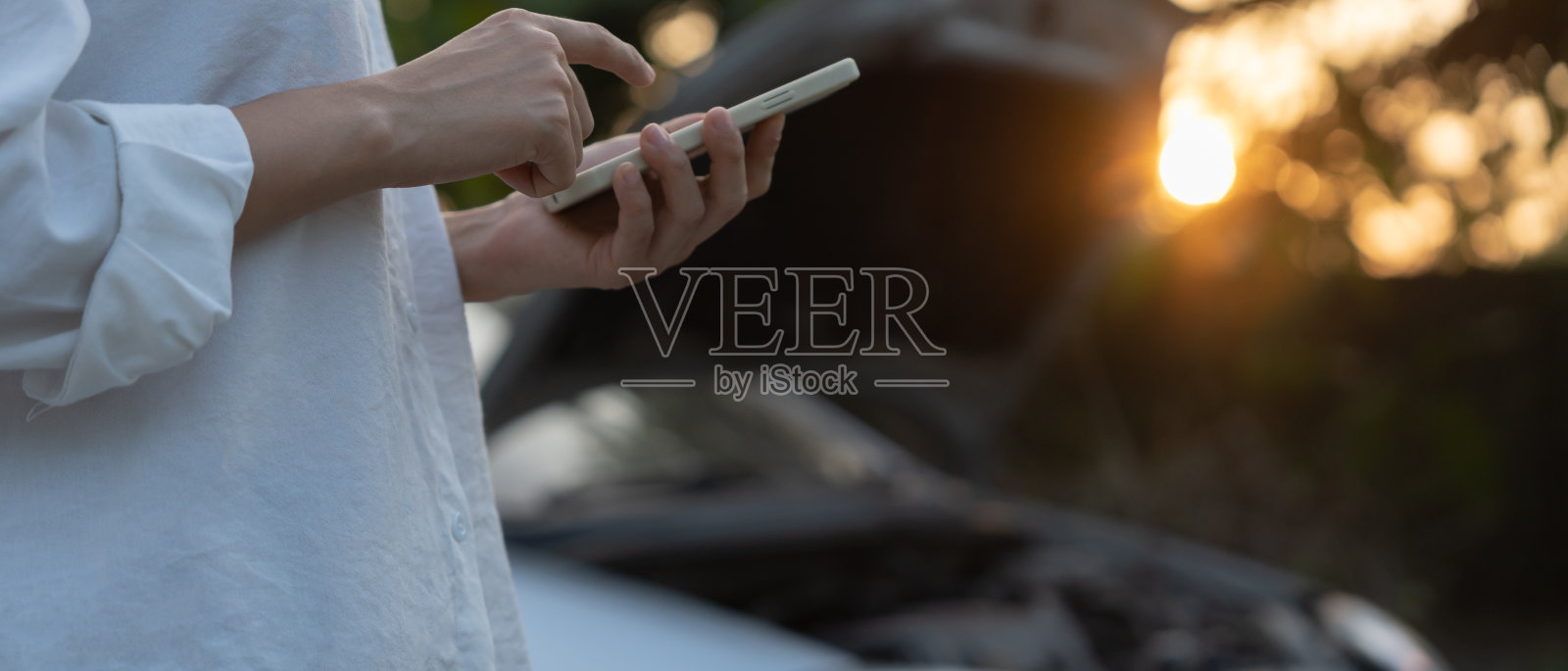 故障，汽车坏了，修理。一名妇女因车祸用手机申请保险费。在乡村旅游期间，寻找汽车修理厂修理汽车，等待帮助，紧急情况。照片摄影图片