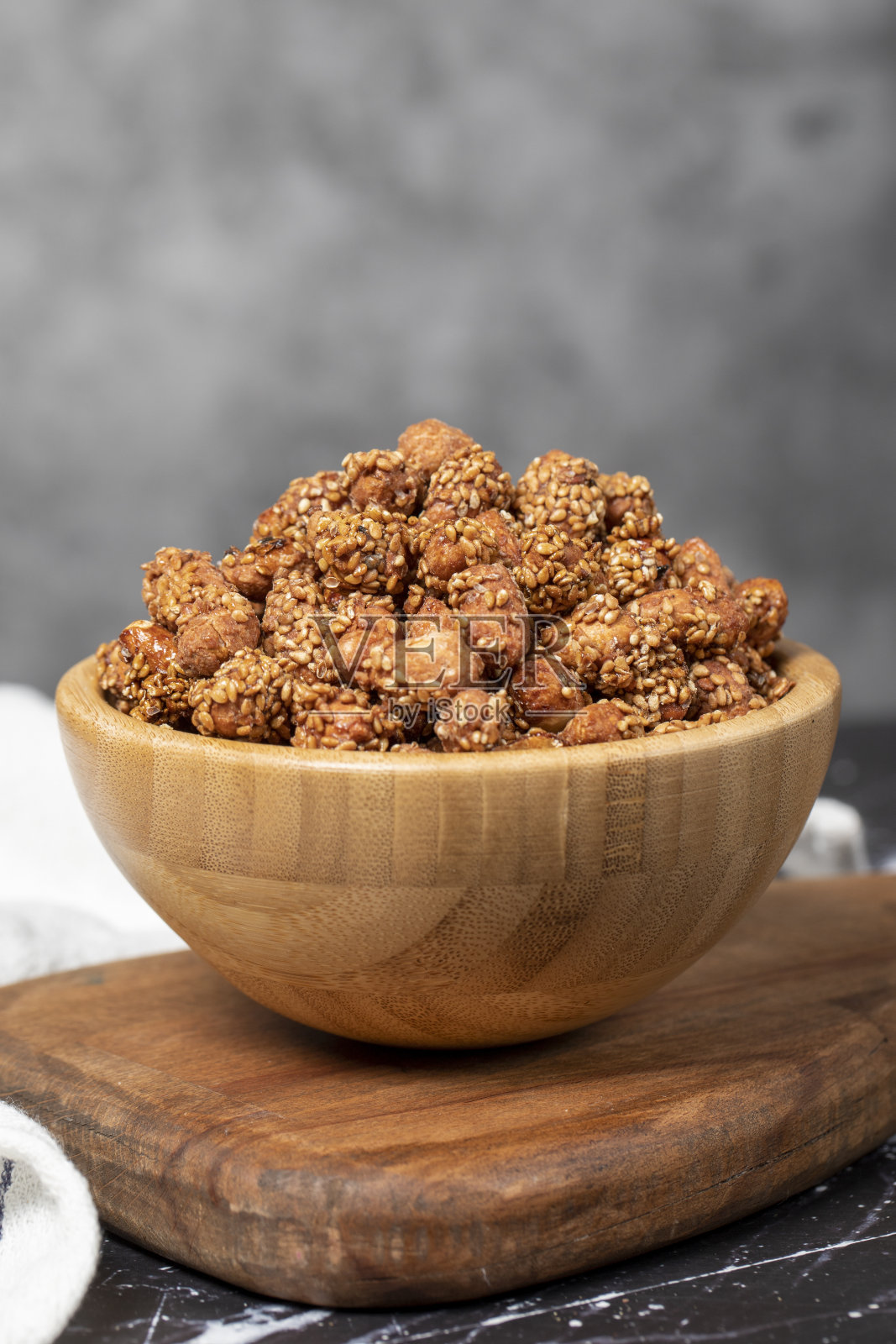 蜂蜜加芝麻花生。木碗芝麻花生。超级食物，素食概念。健康的零食照片摄影图片