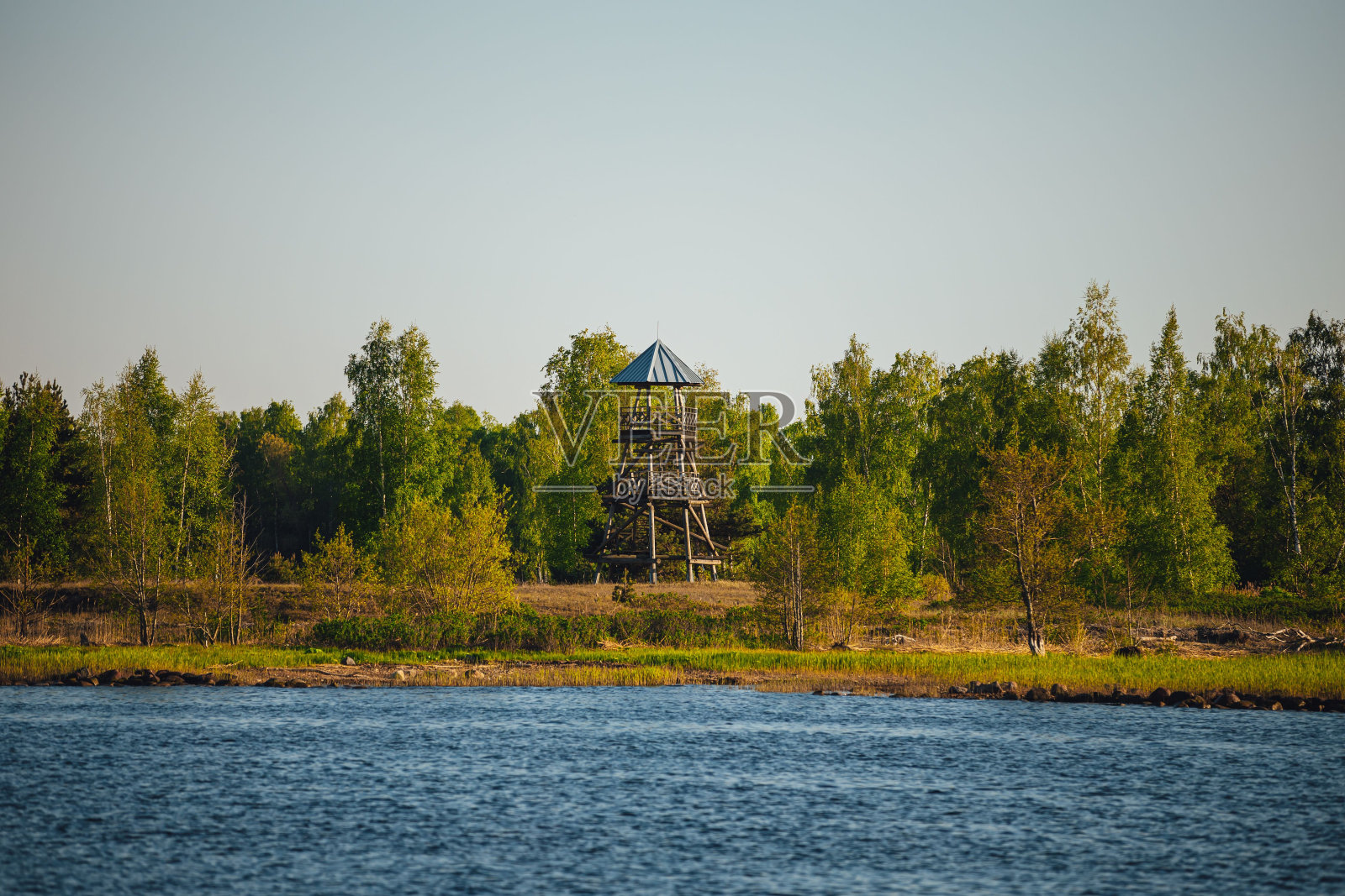 凉亭位于沼泽地带的中央，紧挨着水照片摄影图片