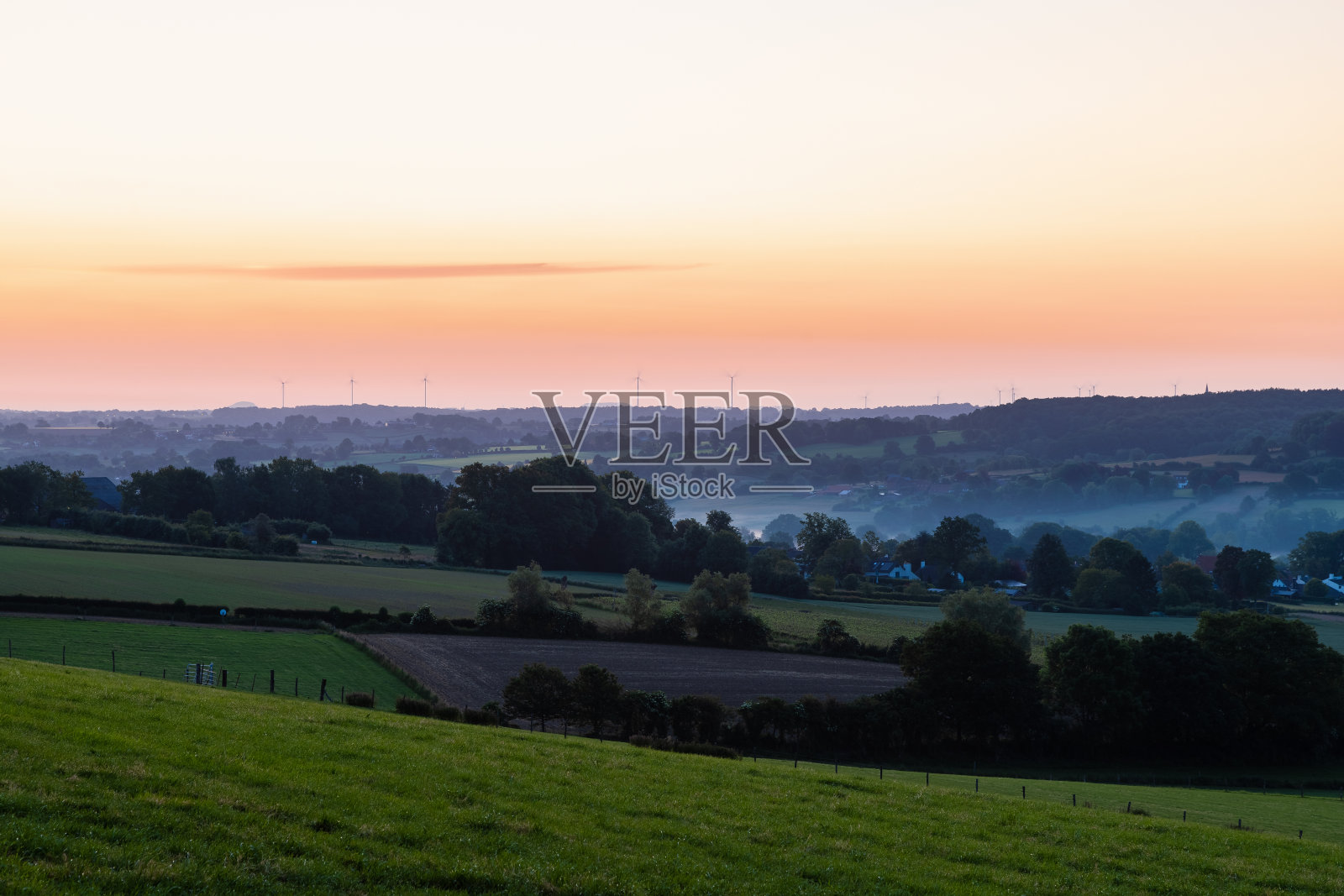 清晨，在林堡连绵起伏的丘陵景观中，日出时天空充满了美丽的色彩照片摄影图片