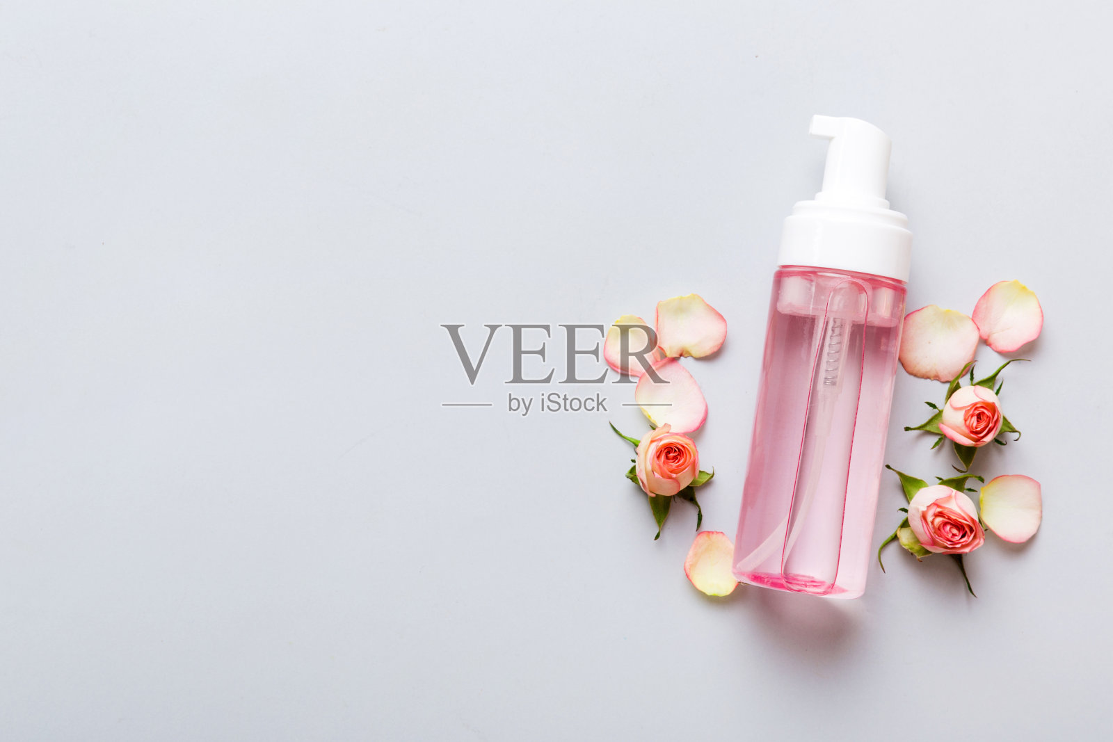 花式保健瓶的精华，胶束，滋补，爽肤水，乳液，水和面霜与玫瑰花。天然有机spa化妆品概念。模型，模板，俯视图照片摄影图片