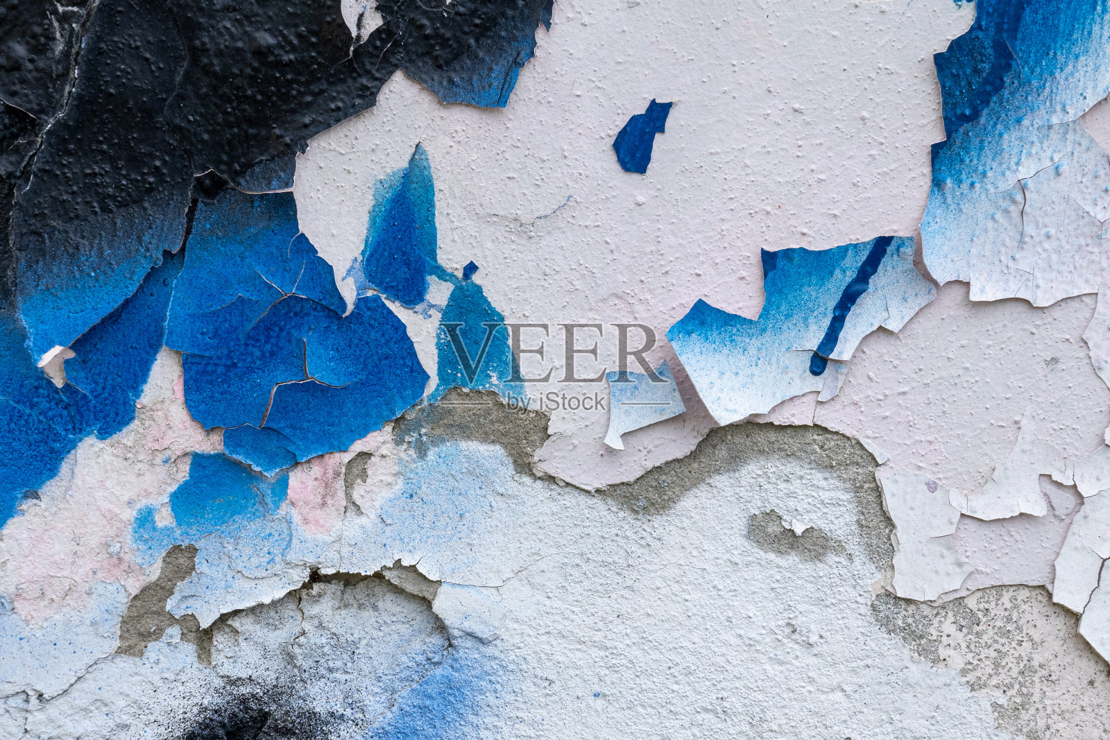 旧混凝土墙上的蓝漆和黑漆正在剥落照片摄影图片