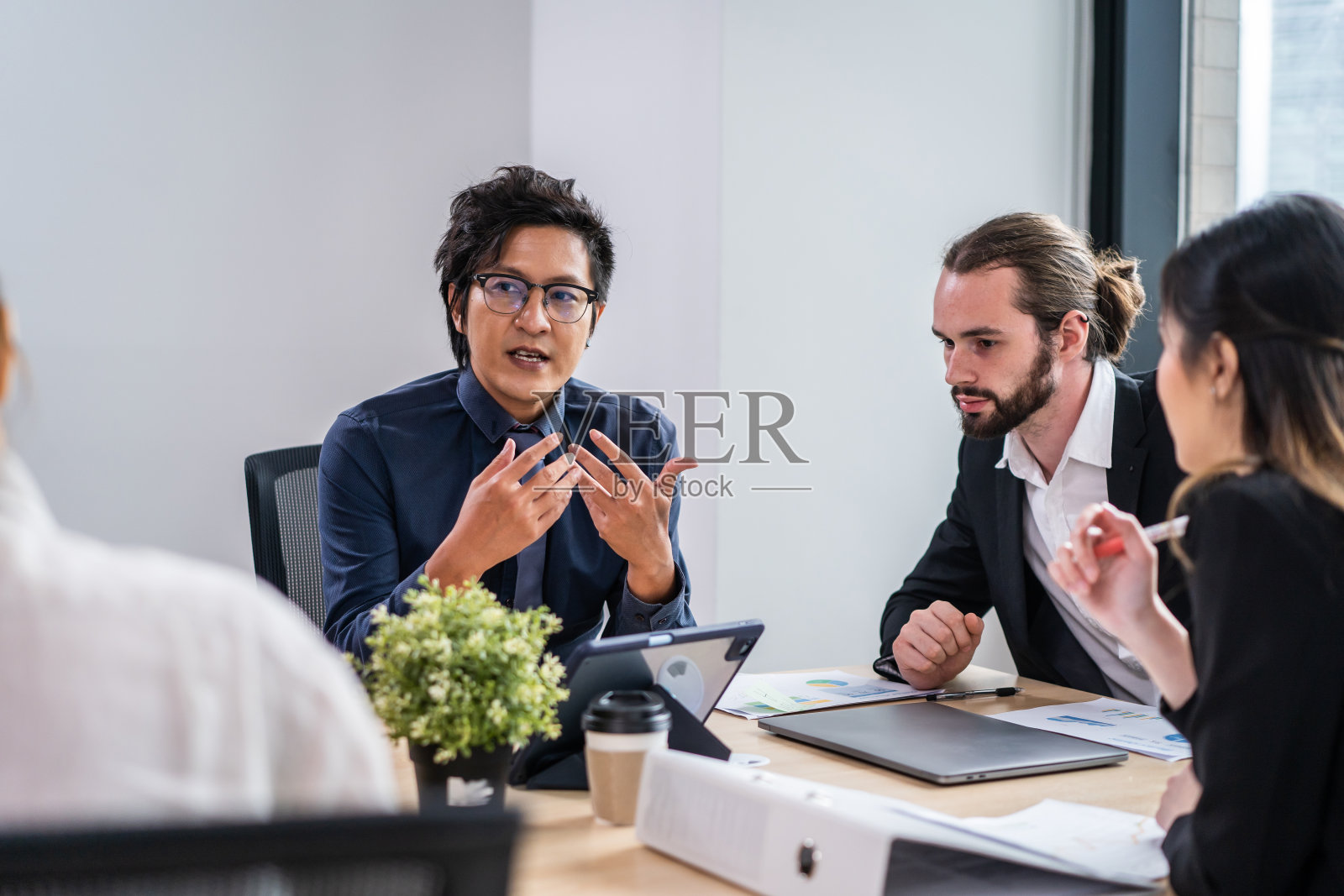 一群在办公室工作的多民族商人和女商人。吸引员工进行头脑风暴和会议，在工作场所计划和讨论项目。现代同事理念的企业照片摄影图片