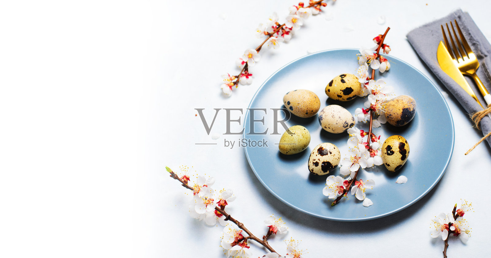 复活节餐桌与鹌鹑蛋和树枝在开花，春假背景照片摄影图片