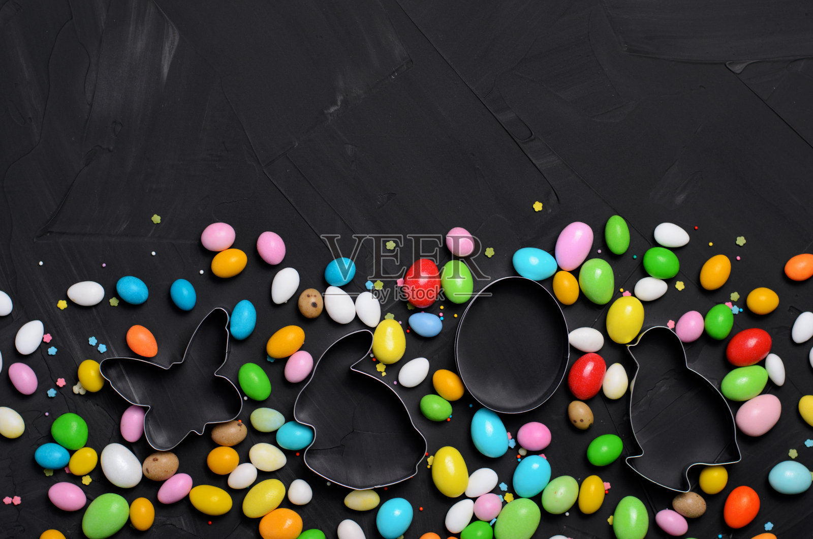 复活节概念，巧克力蛋和饼干切割器黑色背景照片摄影图片