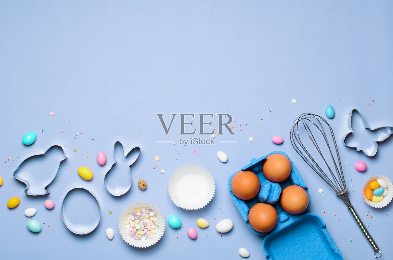 复活节概念，饼干切割器，鸡蛋，糖屑和巧克力蛋在明亮的背景照片摄影图片