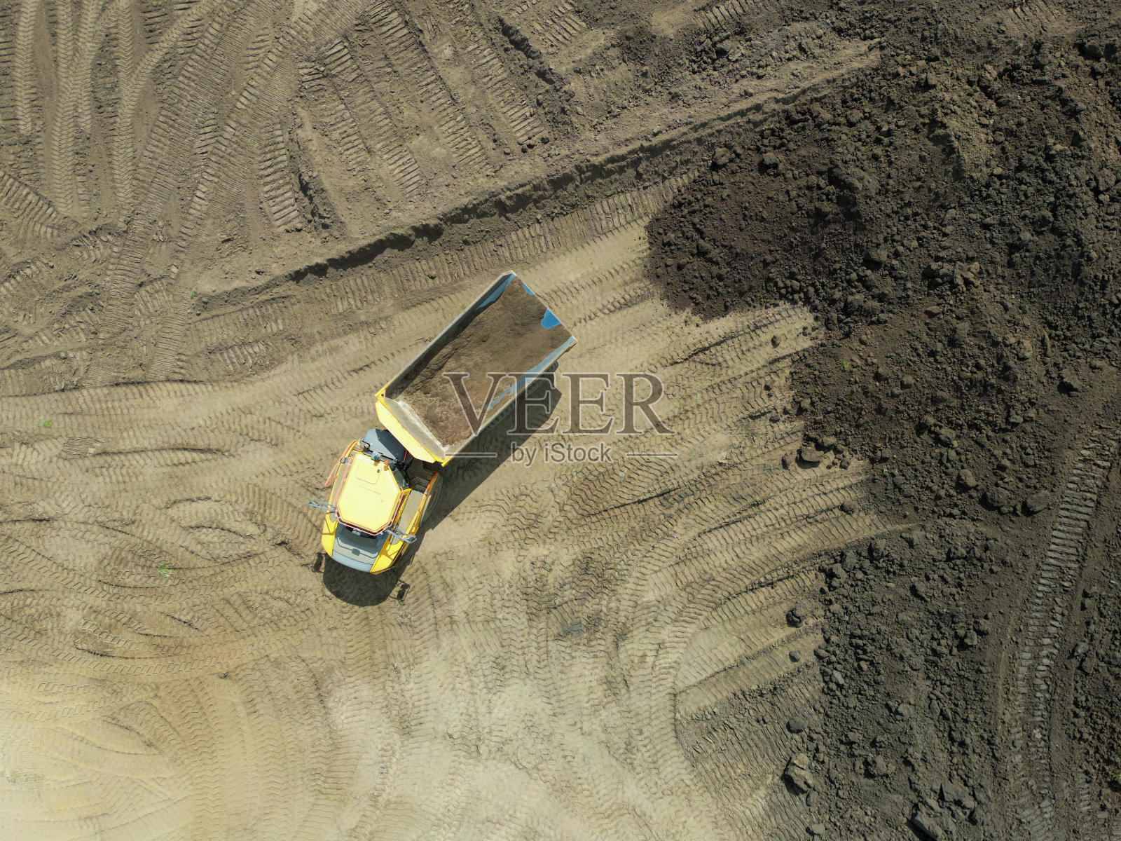 无人机俯瞰一辆典型的大型自卸卡车，出现在一个新的住房建筑工地。照片摄影图片