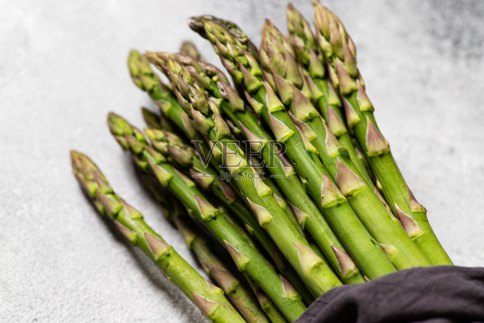 灰色背景上的新鲜绿芦笋。有机蔬菜，纯素健康食品理念。俯视图，复制空间，选择性聚焦照片摄影图片