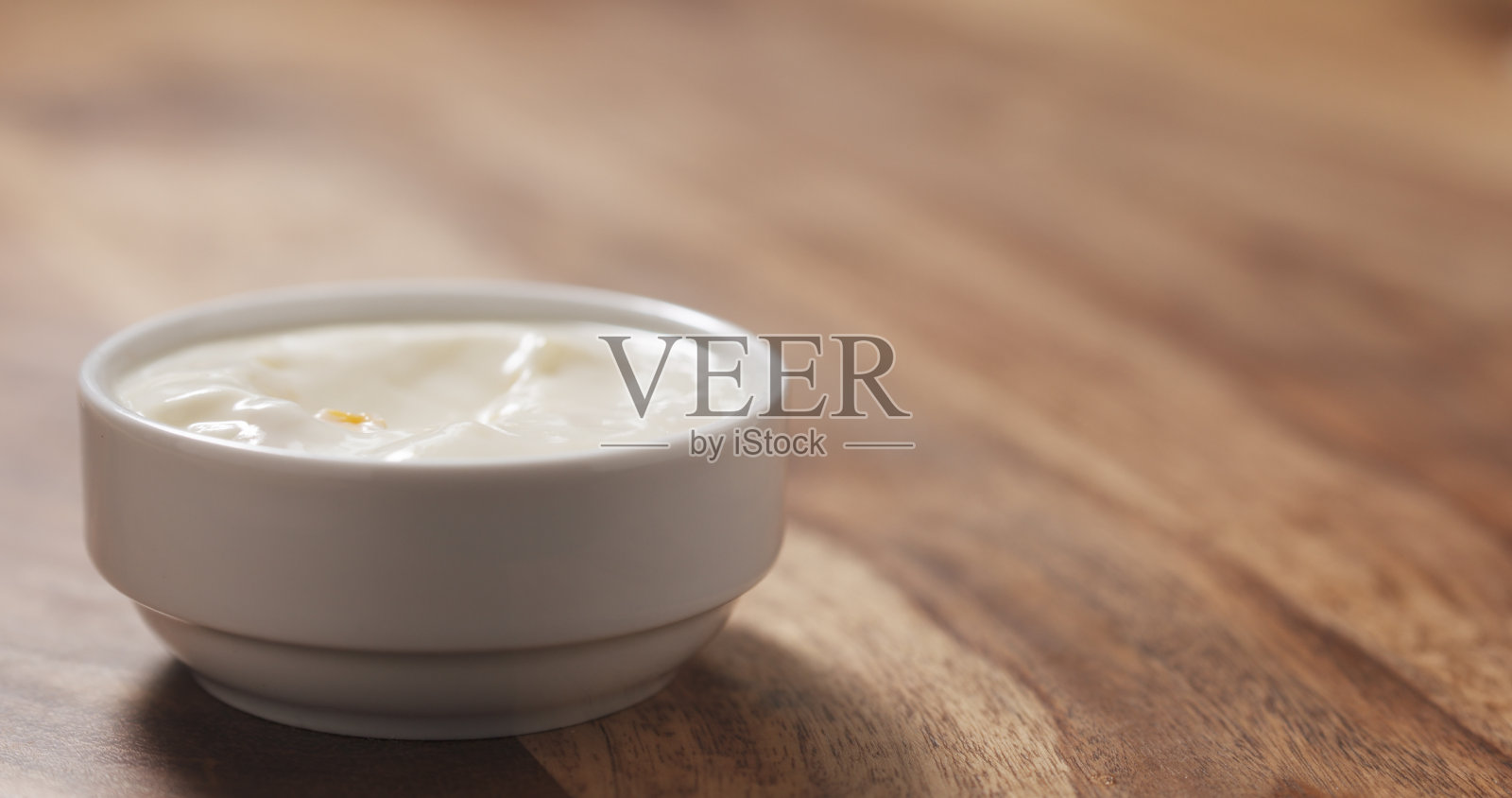 桌上的白碗里装着桃子酸奶照片摄影图片