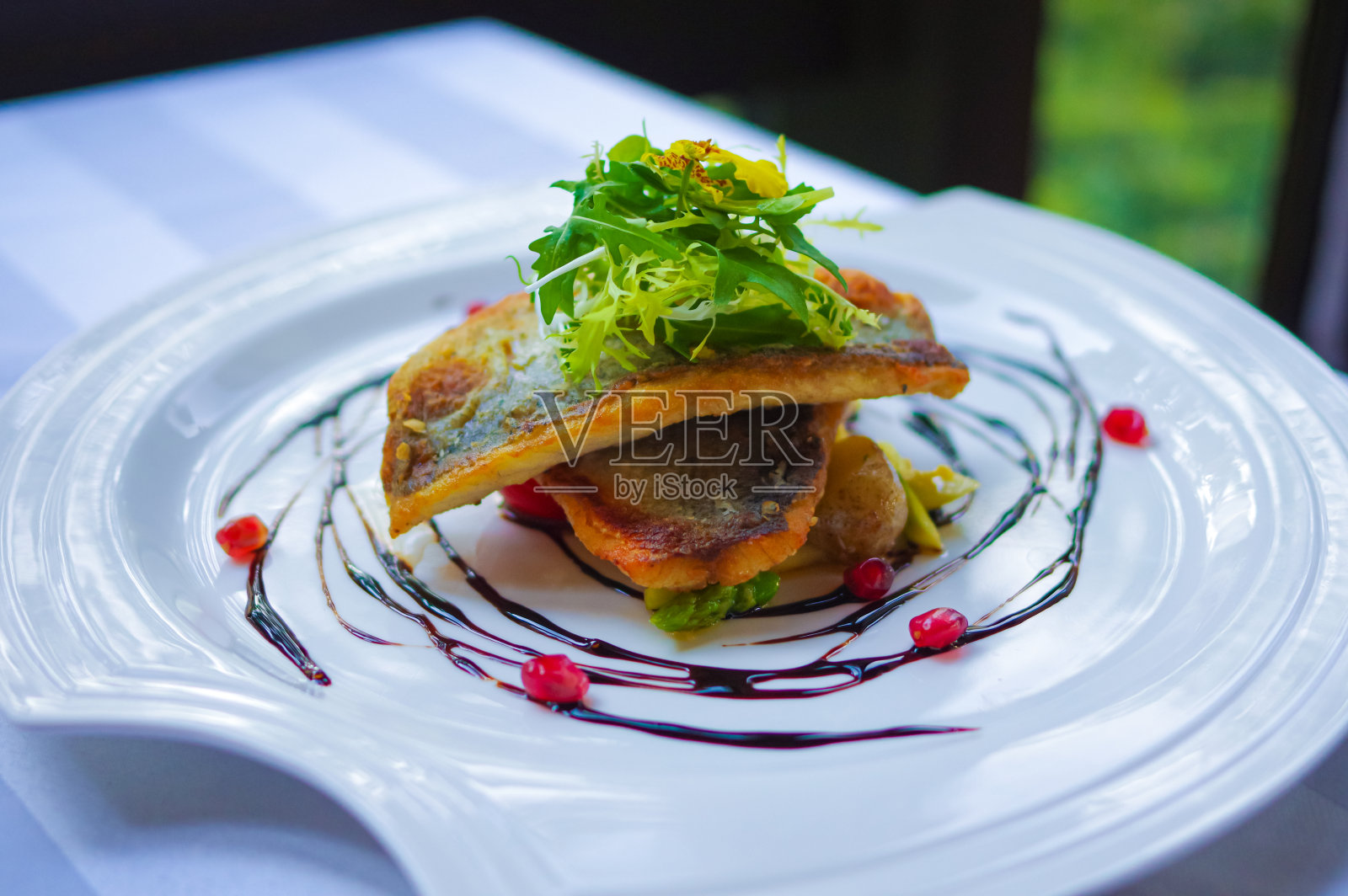 香脆香煎鲈鱼片配石榴籽照片摄影图片