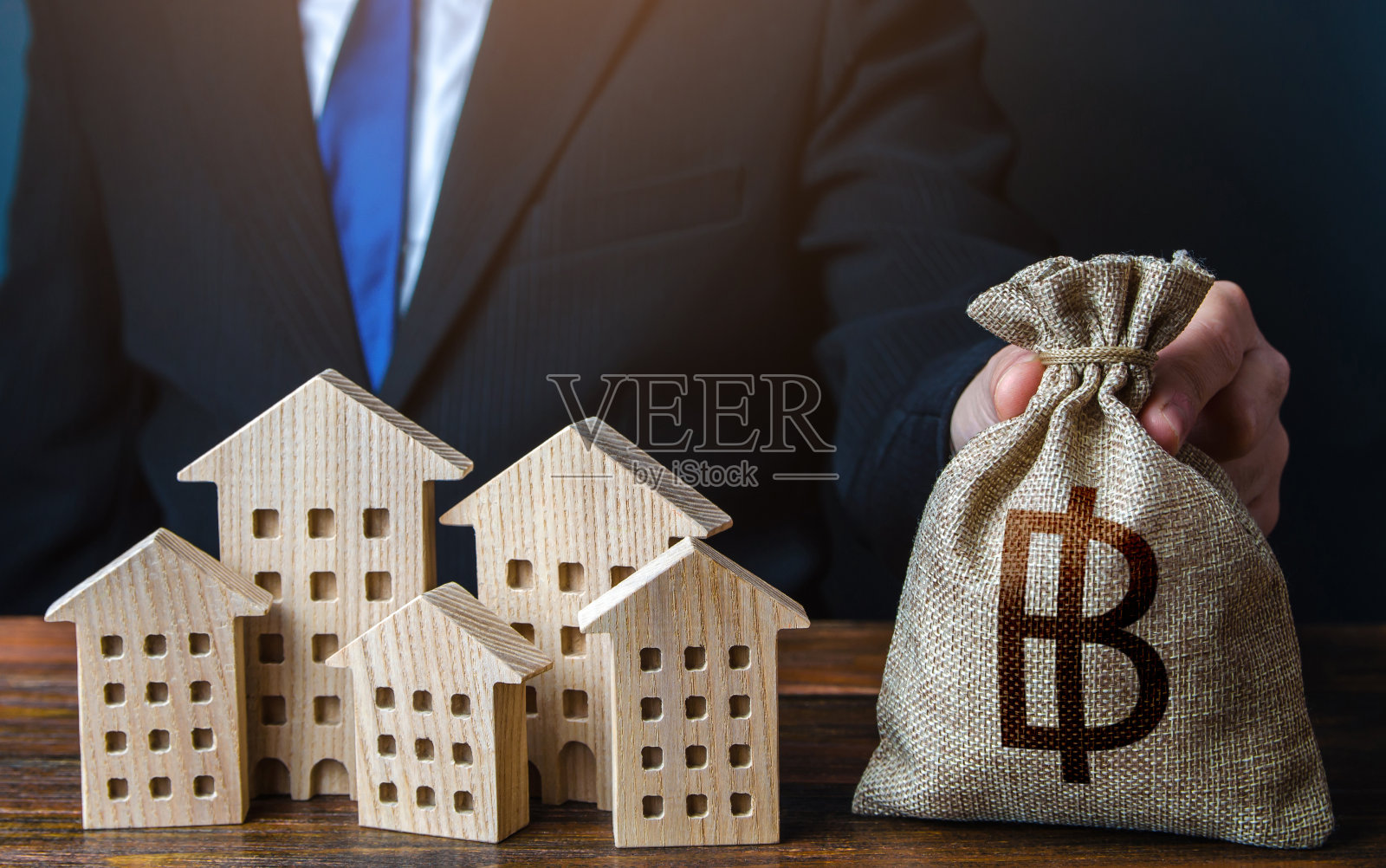 一个商人在房子附近放了一个泰铢钱袋。照片摄影图片