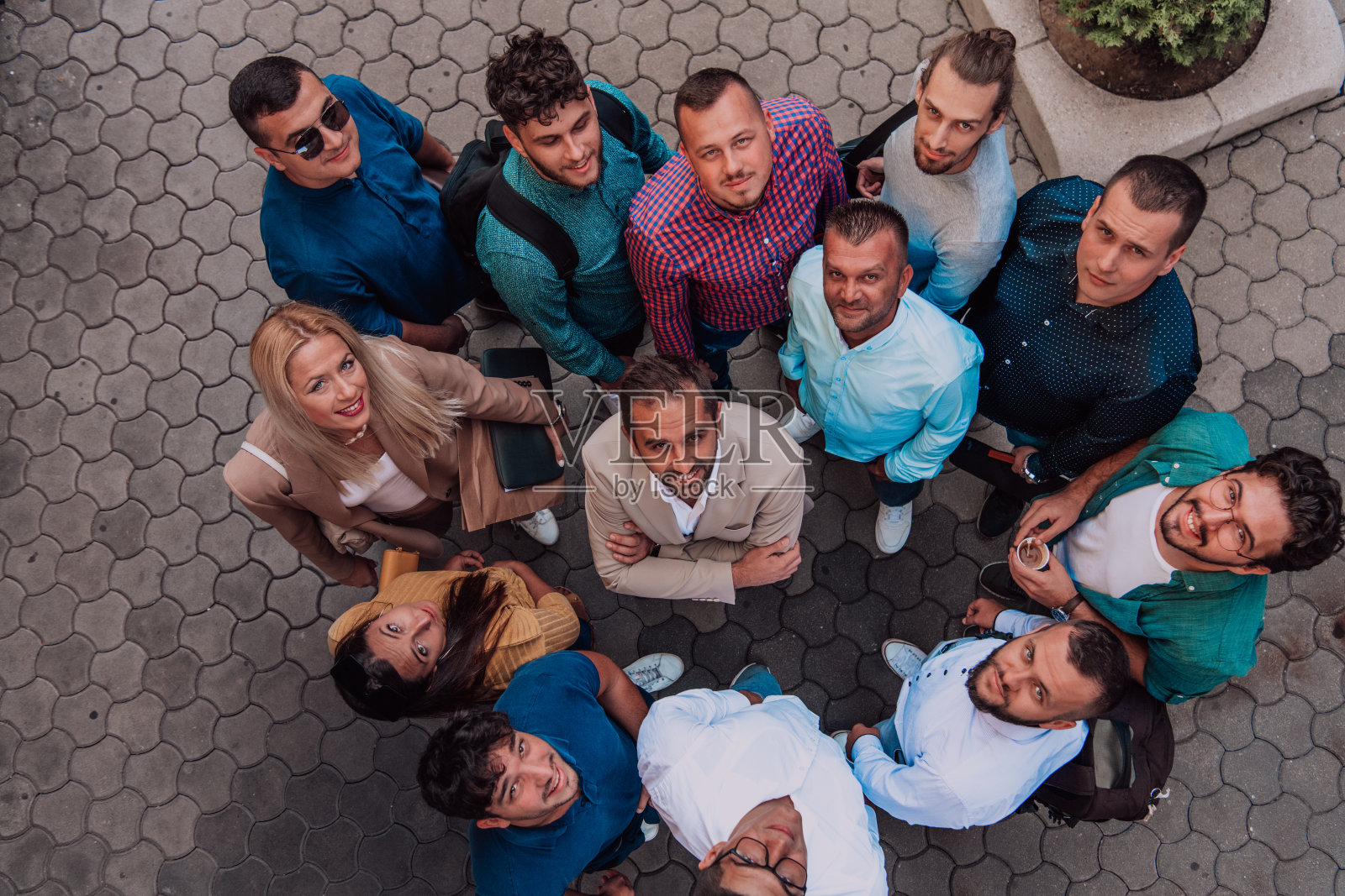 一群商人和同事站在一起，看着镜头，象征着团结和团队精神。照片摄影图片