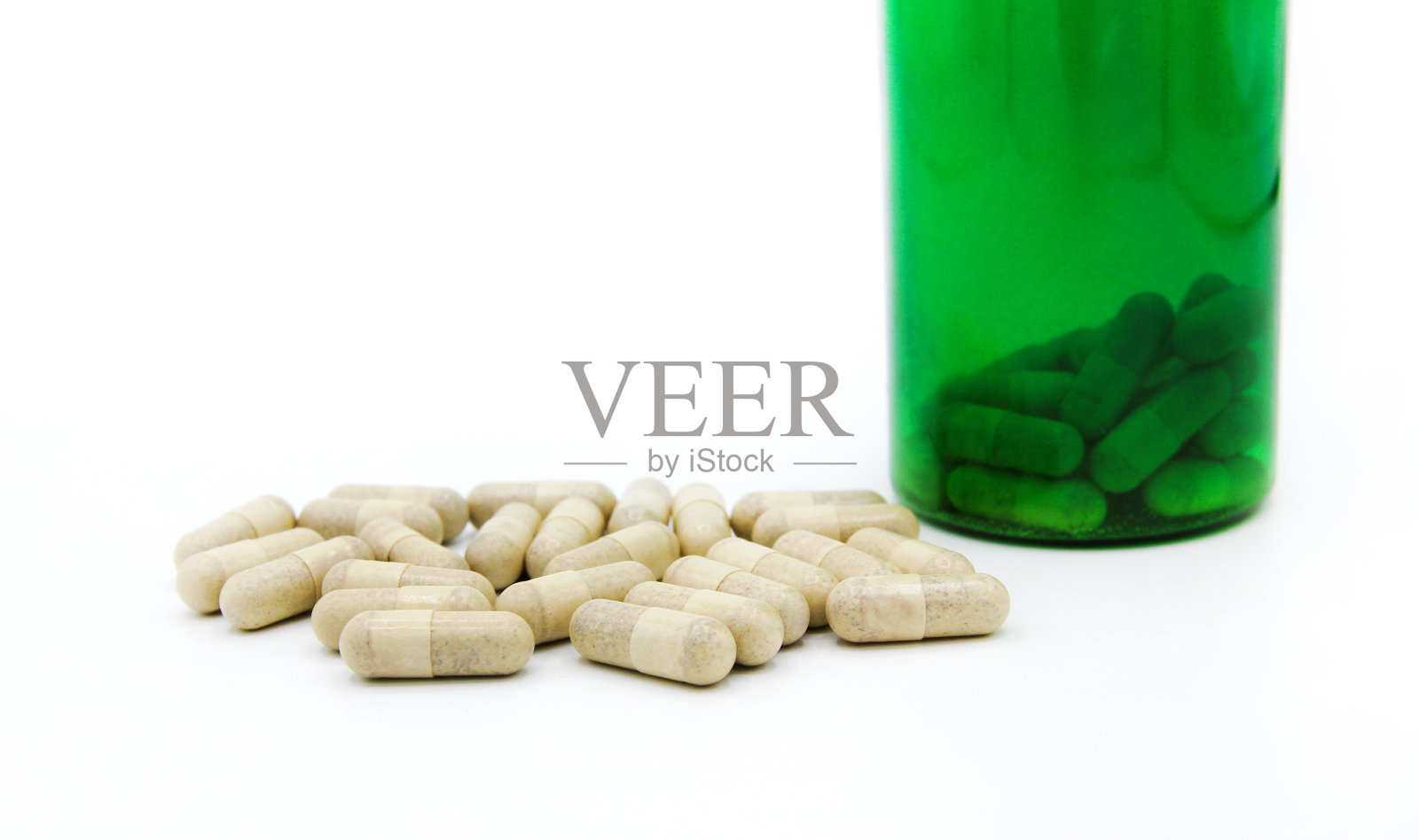 白色药丸或胶囊与绿色药瓶隔离在白色背景与复制空间添加文字。照片摄影图片