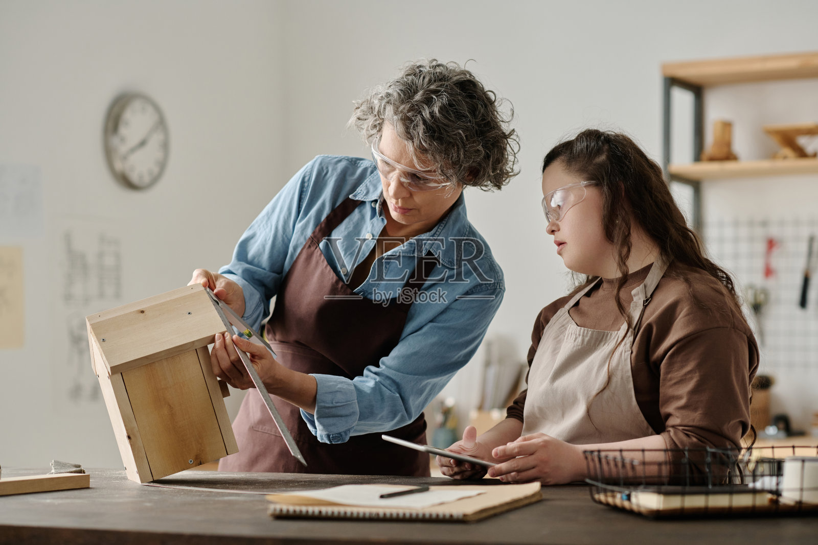 女孩和木匠用尺子测量房子照片摄影图片