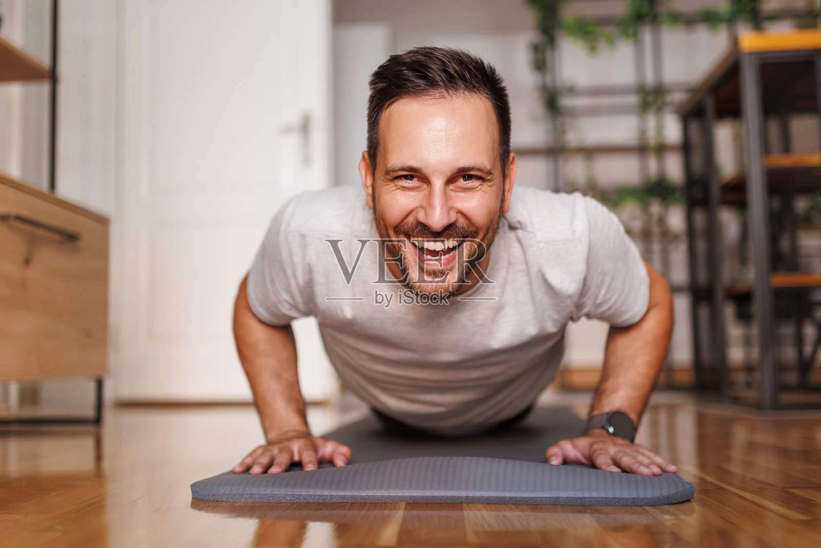 男子在家锻炼时做俯卧撑照片摄影图片