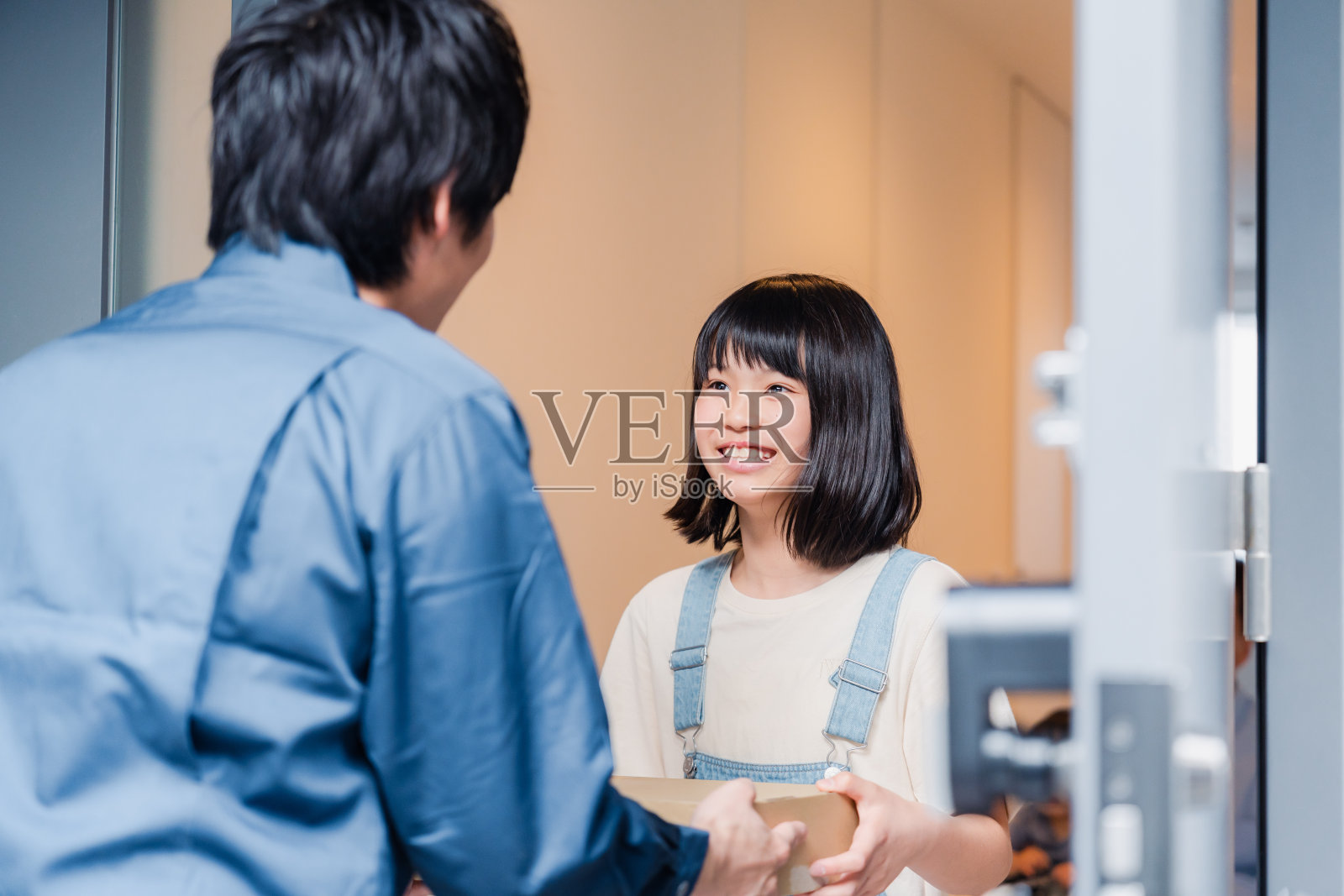 小学女生在家里收到快递照片摄影图片