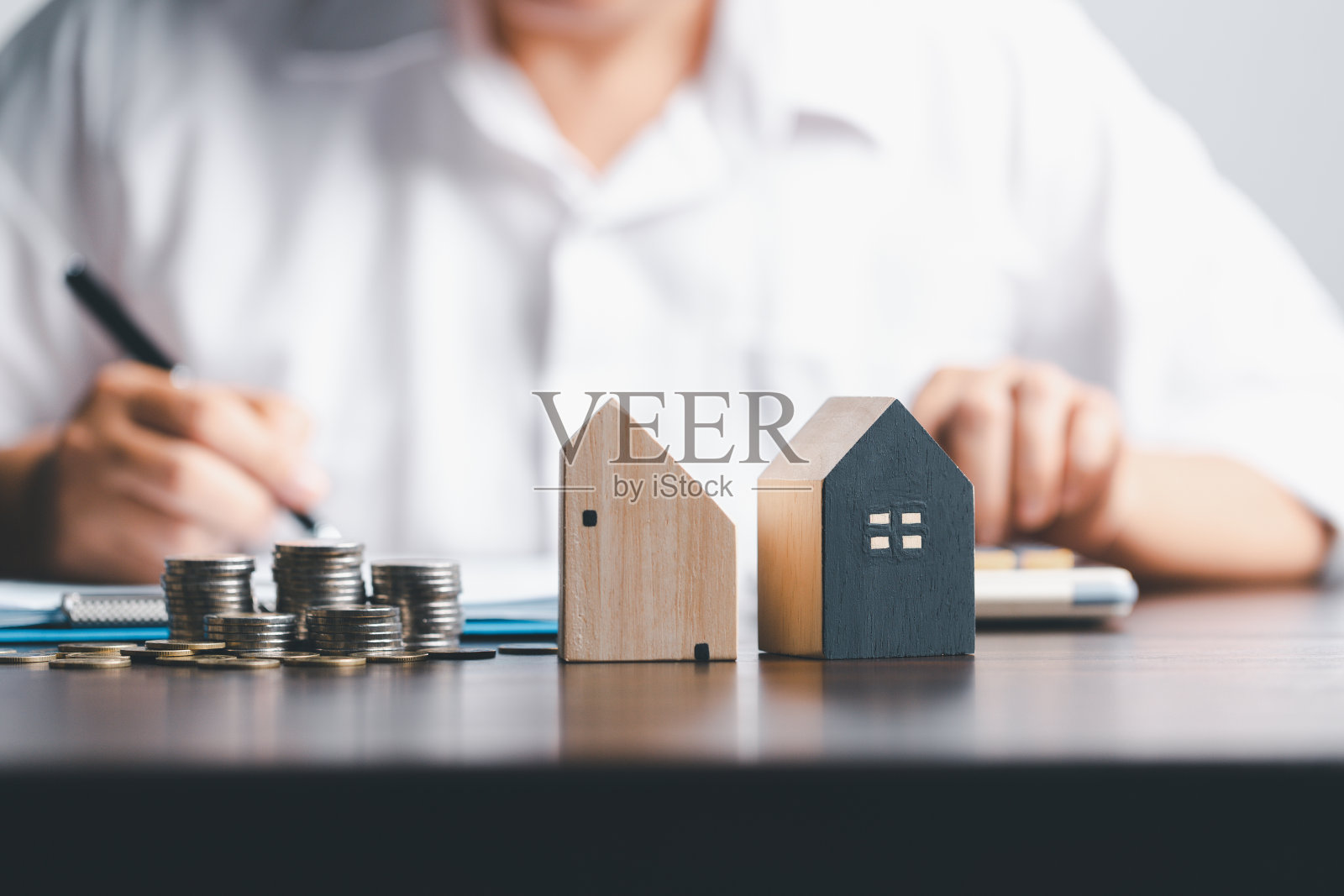 房地产经纪人在投标房屋项目中向客户详细解释。房屋模型与专业的房地产经纪人在办公室与客户签订租赁合同。照片摄影图片