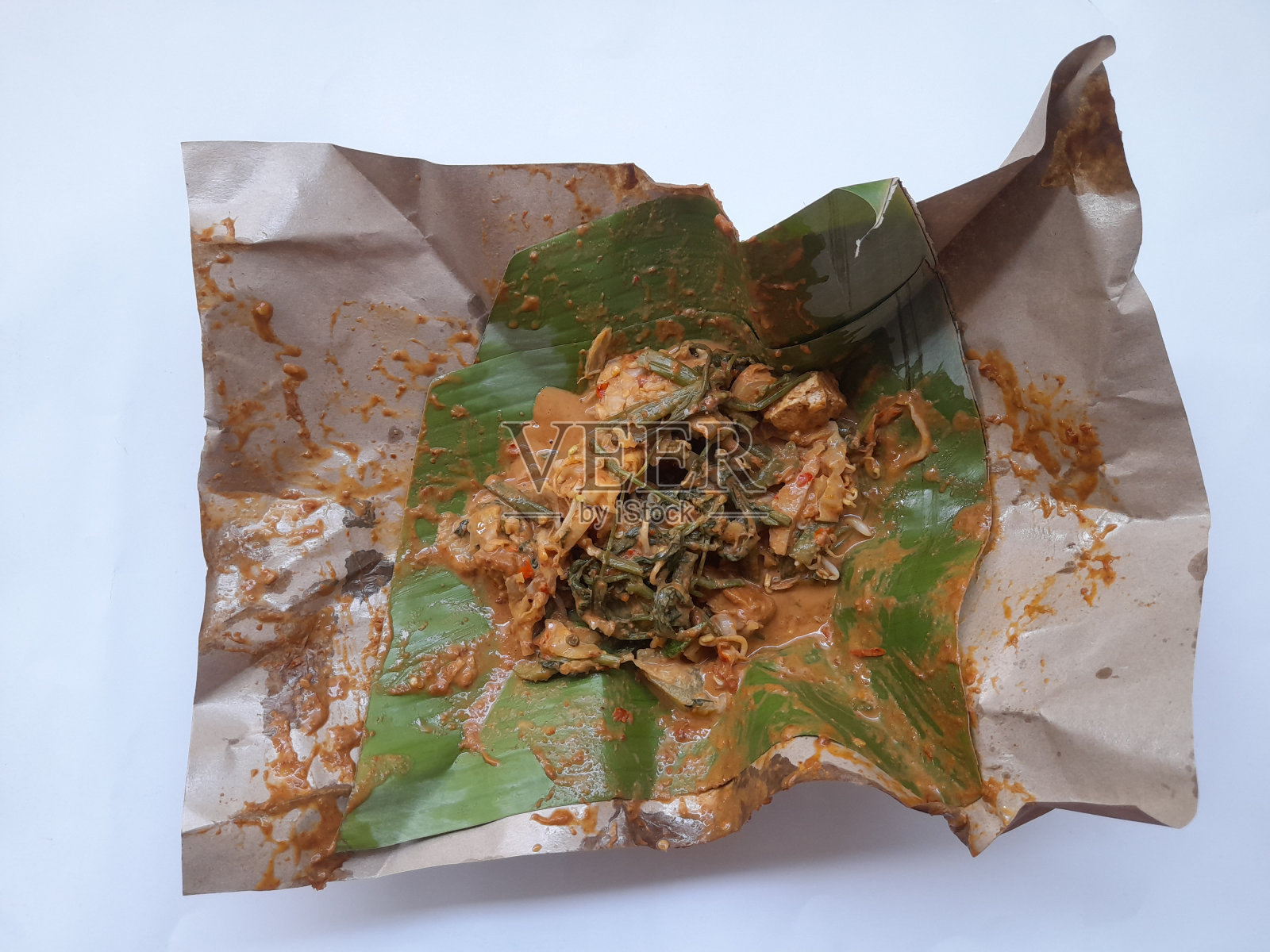 加多加多食物，在白色背景的香蕉叶上涂上花生酱。照片摄影图片