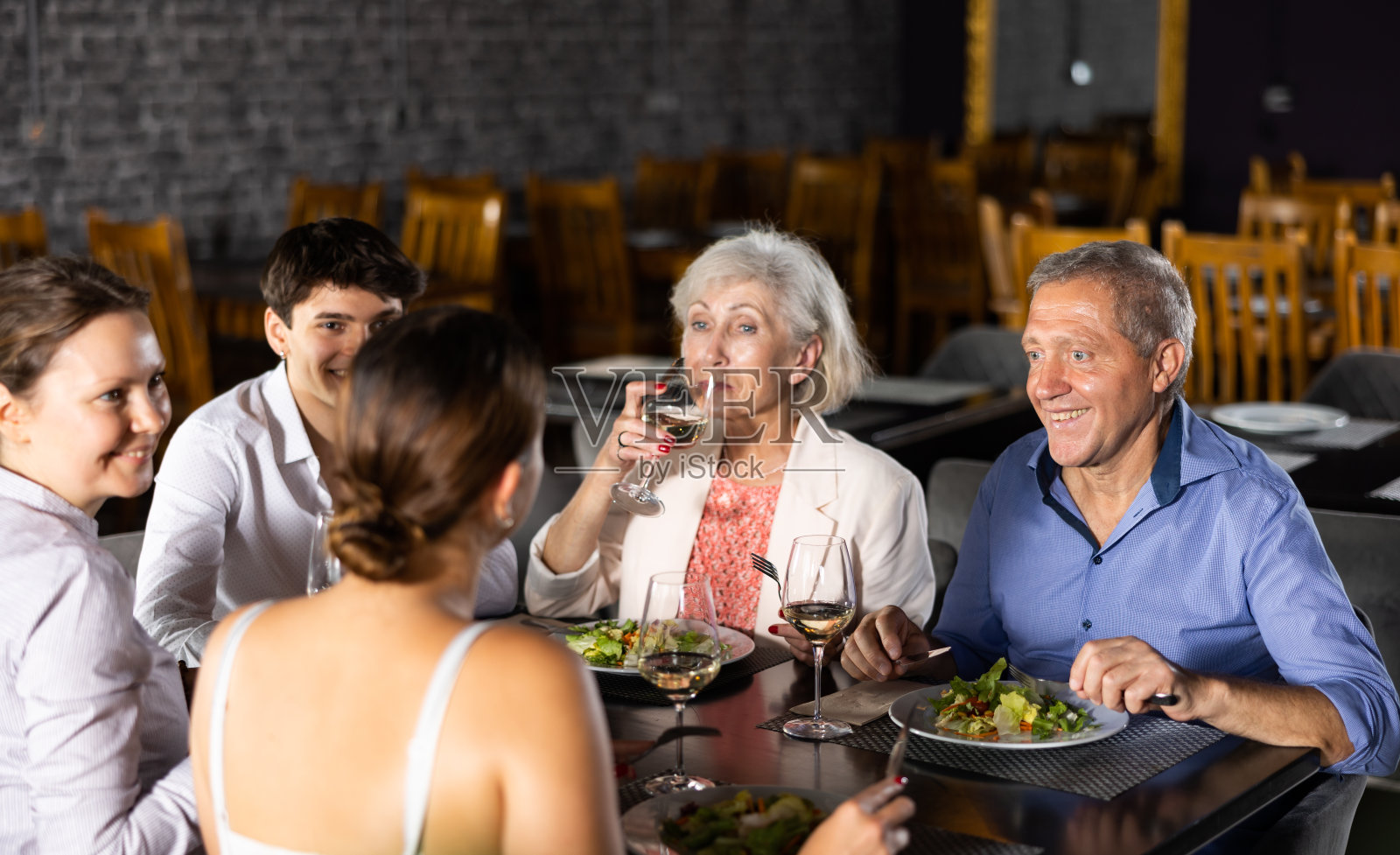 大家庭，配偶的陪伴在餐厅，吃饭，庆祝重要事件，交流。照片摄影图片