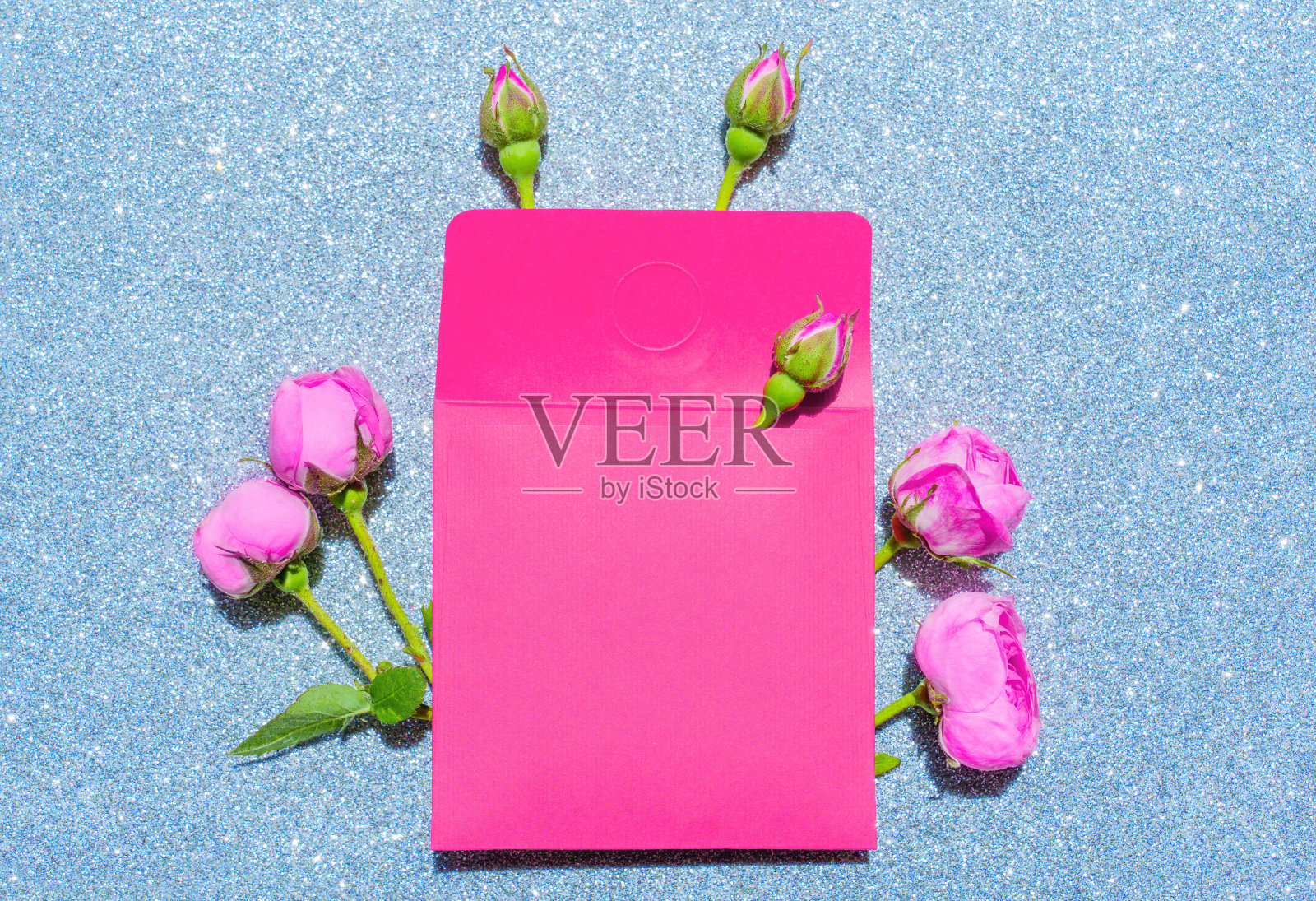 粉红色信封与玫瑰在闪闪发光的银色背景照片摄影图片