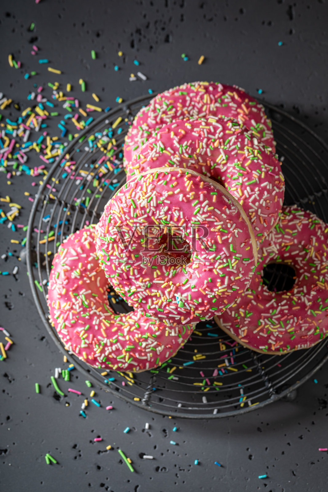 自制的粉色甜甜圈准备好吃了。照片摄影图片