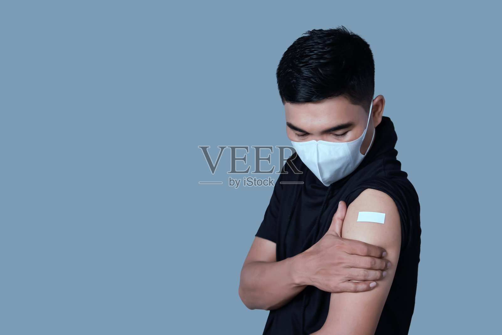 接种疫苗的亚洲成年男子展示胶布绷带照片摄影图片