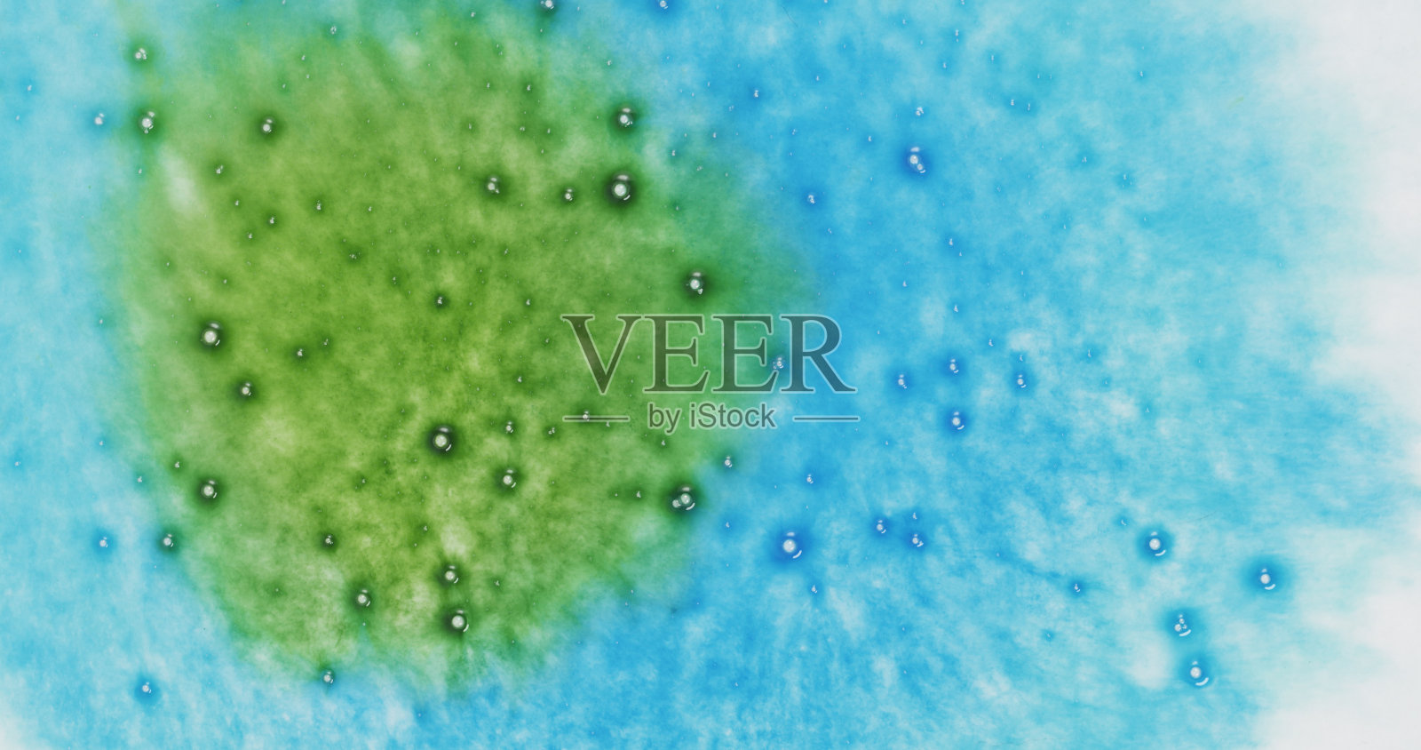 水喷绿色墨水在湿的蓝色纸上俯视图照片摄影图片