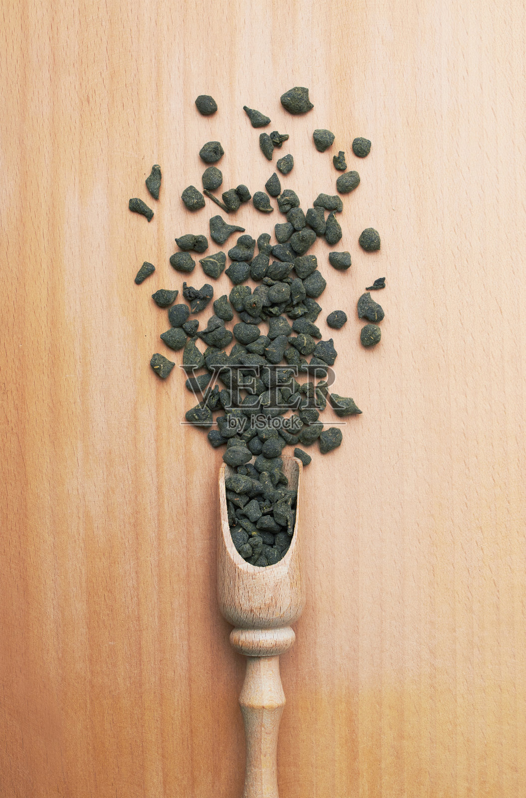 用木勺盛茶，放在木头上照片摄影图片
