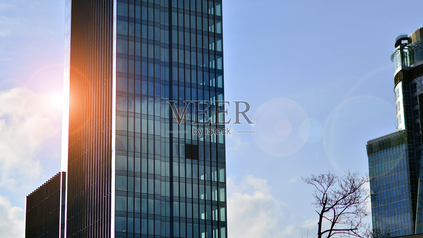 抬头看市中心的商业大厦。蓝天映衬下的现代办公楼。照片摄影图片