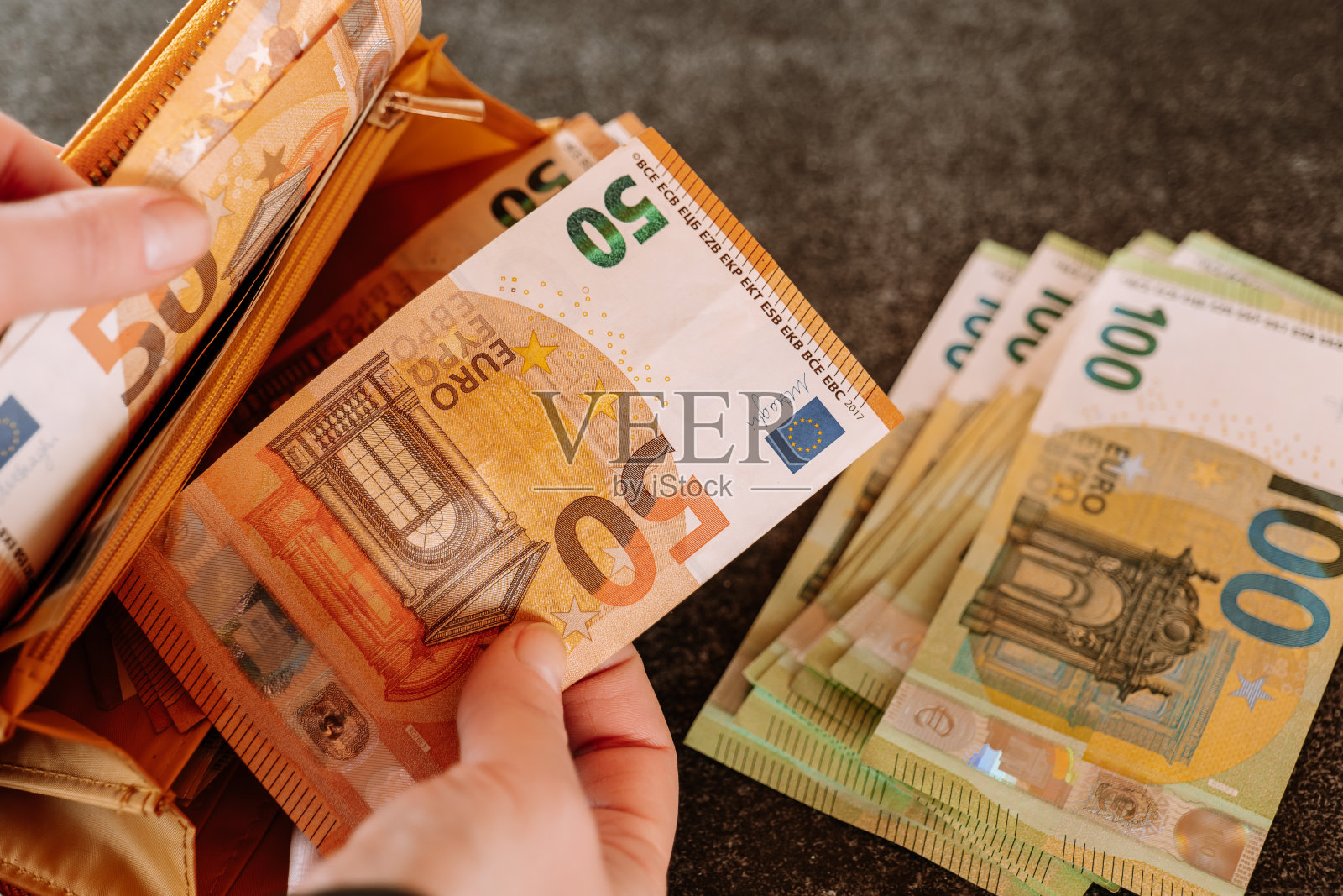 汉德从钱包里拿出一张欧元钞票。欧元区的收入和支出。钱包里有钱。照片摄影图片