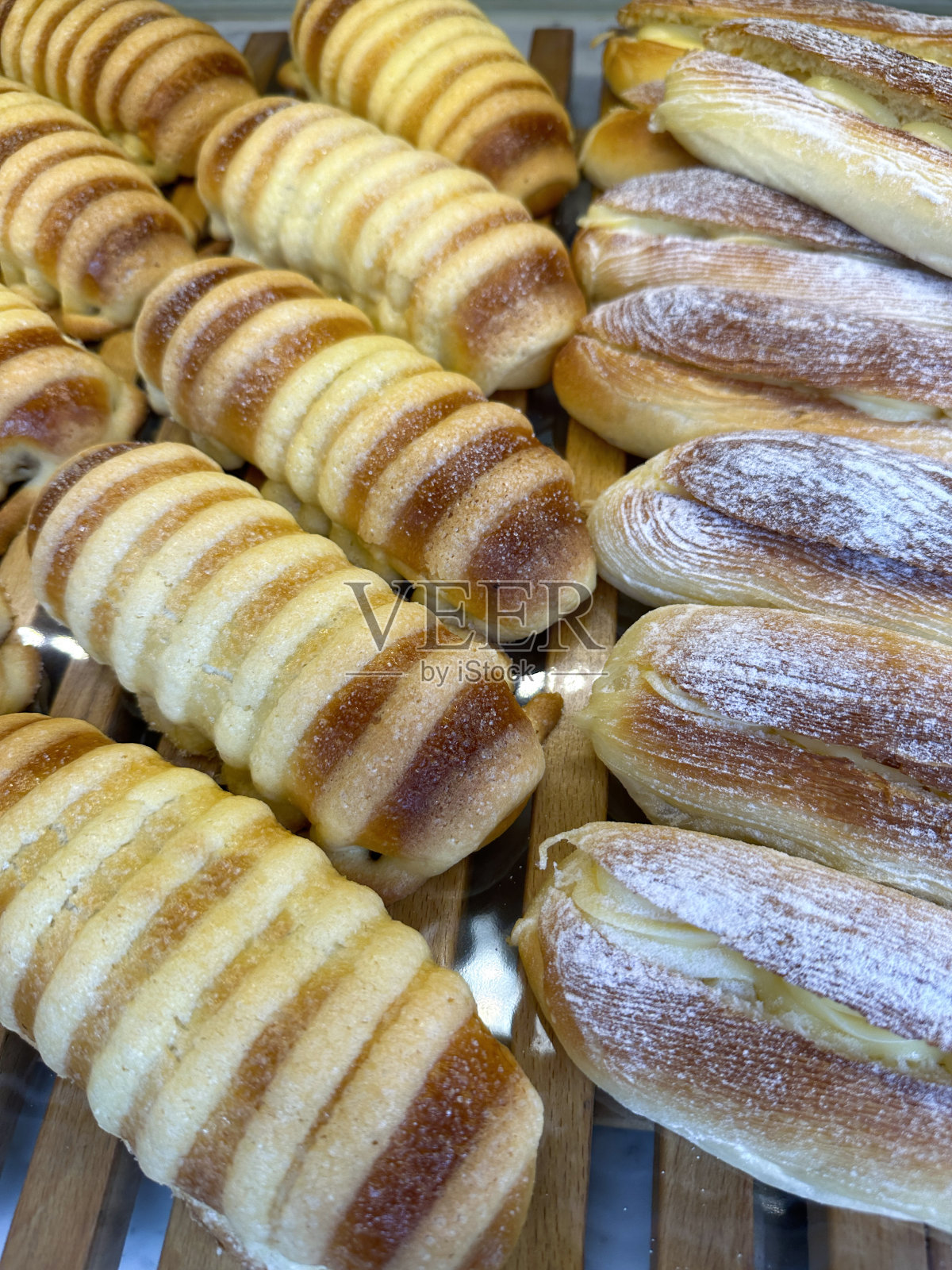 木质面包店货架上一排排新鲜出炉的苹果酥皮糕点的特写图像，高架视图，聚焦于前景照片摄影图片