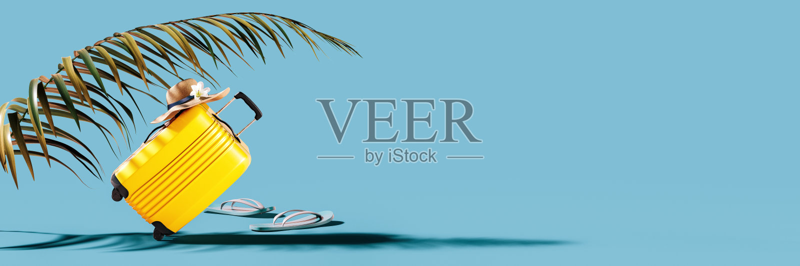 黄色行李袋与帽子和棕榈叶在蓝色背景与复制空间。照片摄影图片