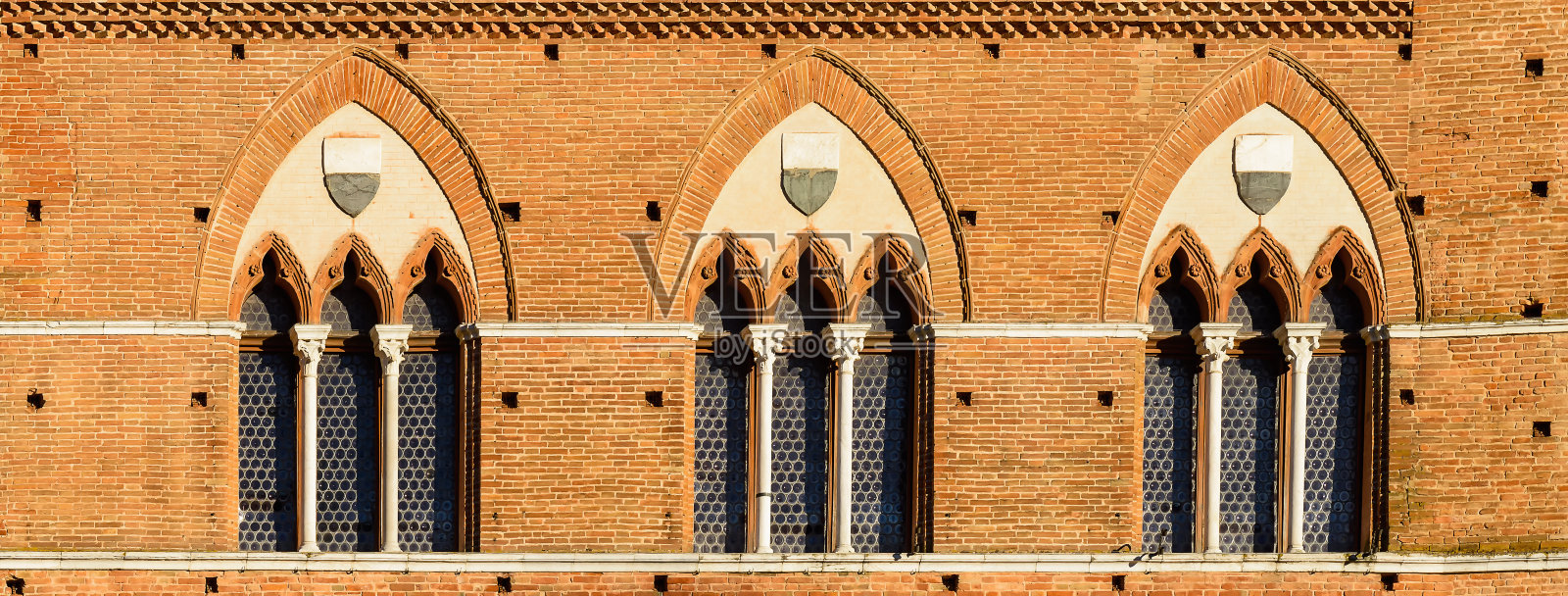 锡耶纳有窗户的老墙。意大利托斯卡纳锡耶纳的建筑。Publico宫和Mangia塔照片摄影图片