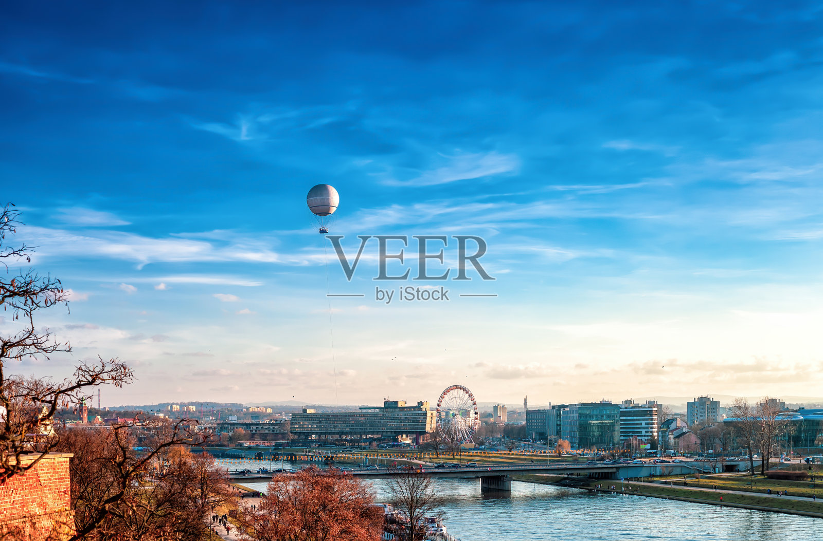 波兰的克拉科夫市，维斯瓦河上有热气球和摩天轮照片摄影图片