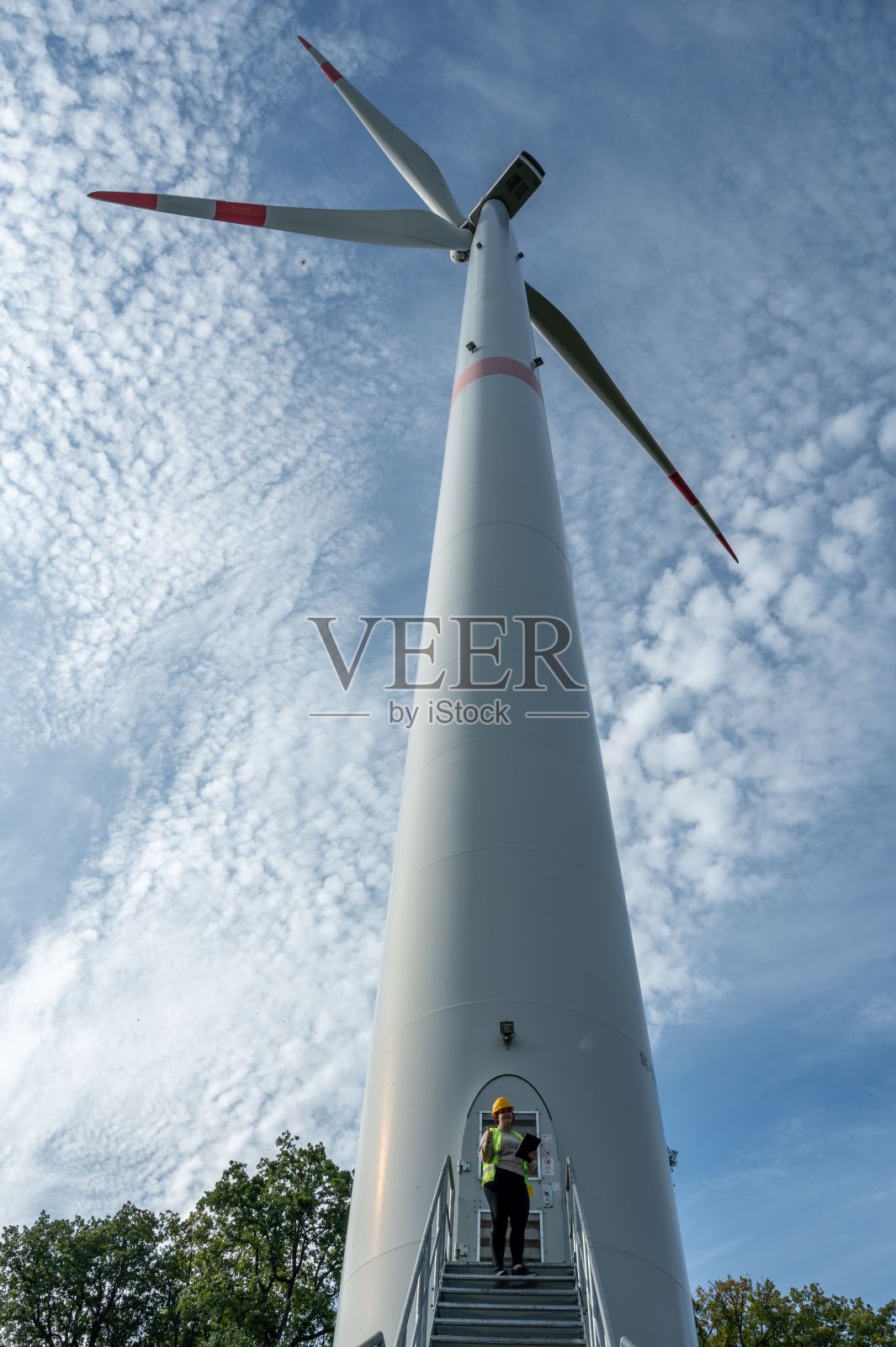 穿着安全防护背心的女工程师站在楼梯上照片摄影图片