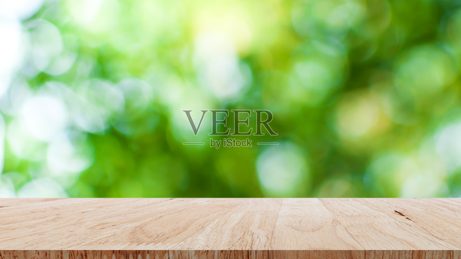 空棕色木桌与抽象模糊的绿色散景背景，为宣传和广告产品展示照片摄影图片