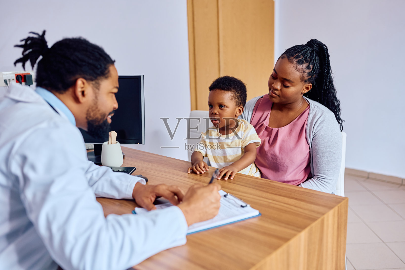 可爱的黑人小孩和他妈妈在诊所和医生谈话。照片摄影图片