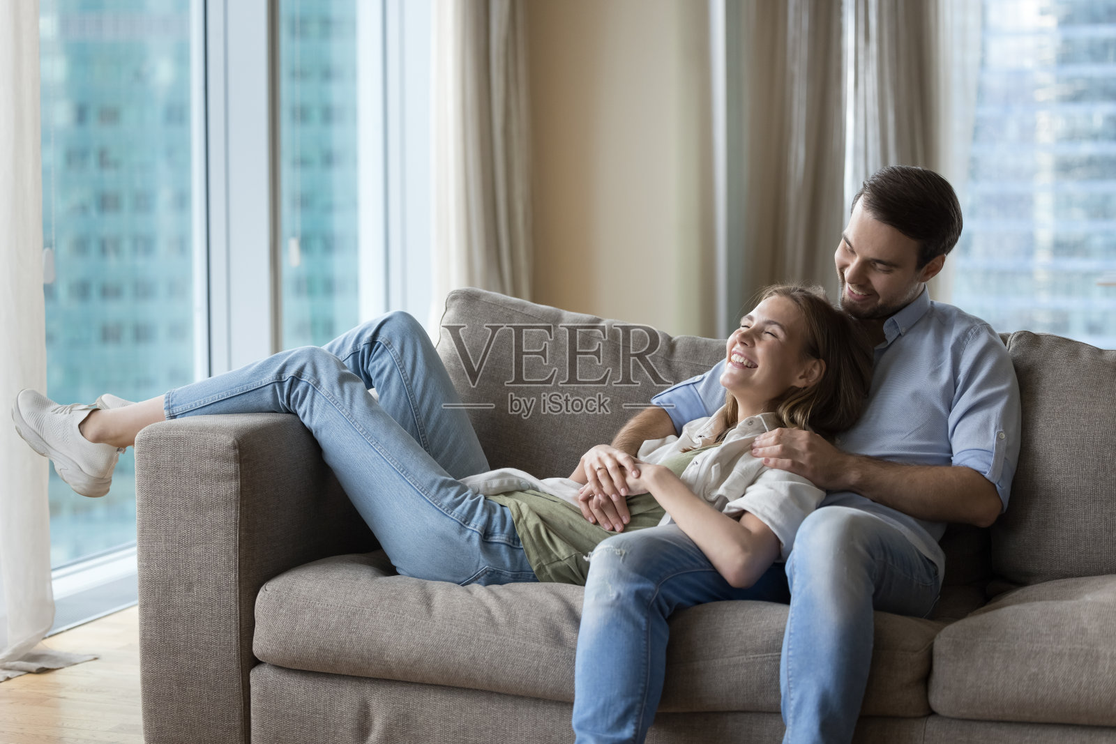 幸福的丈夫和妻子一起躺在舒适的沙发上照片摄影图片