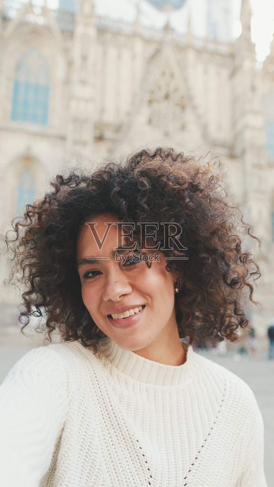 近距离看，年轻女子正坐在手机前。女孩在旧城背景下自拍照片摄影图片