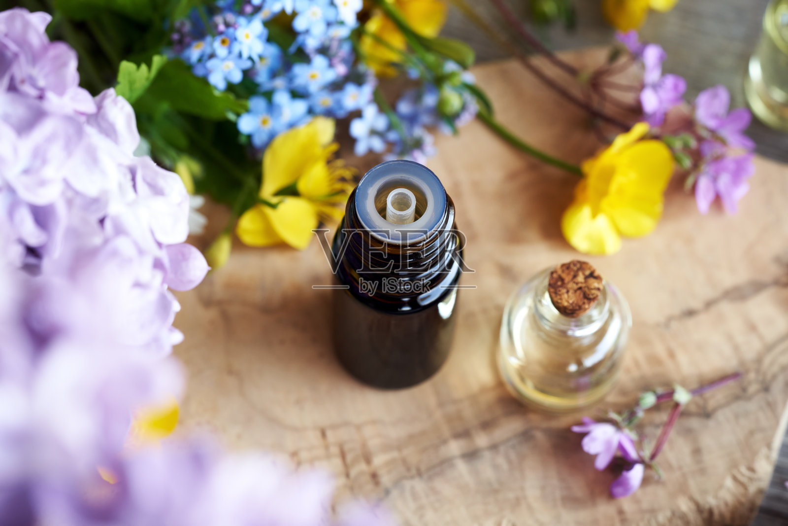 滴瓶精油与五颜六色的花朵照片摄影图片