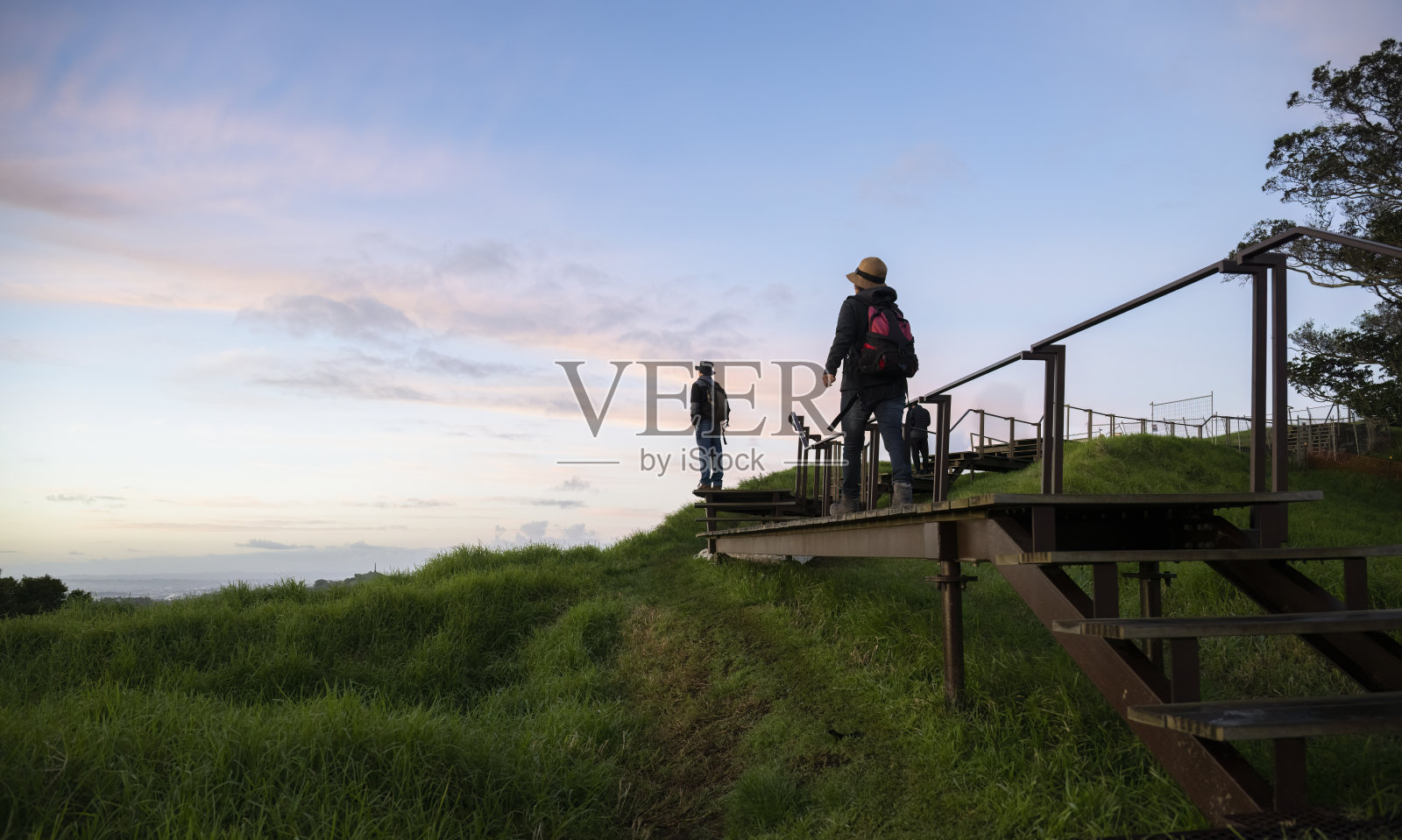 在伊甸山顶的火山口周围，人们走在凸起的木板路上。奥克兰。照片摄影图片